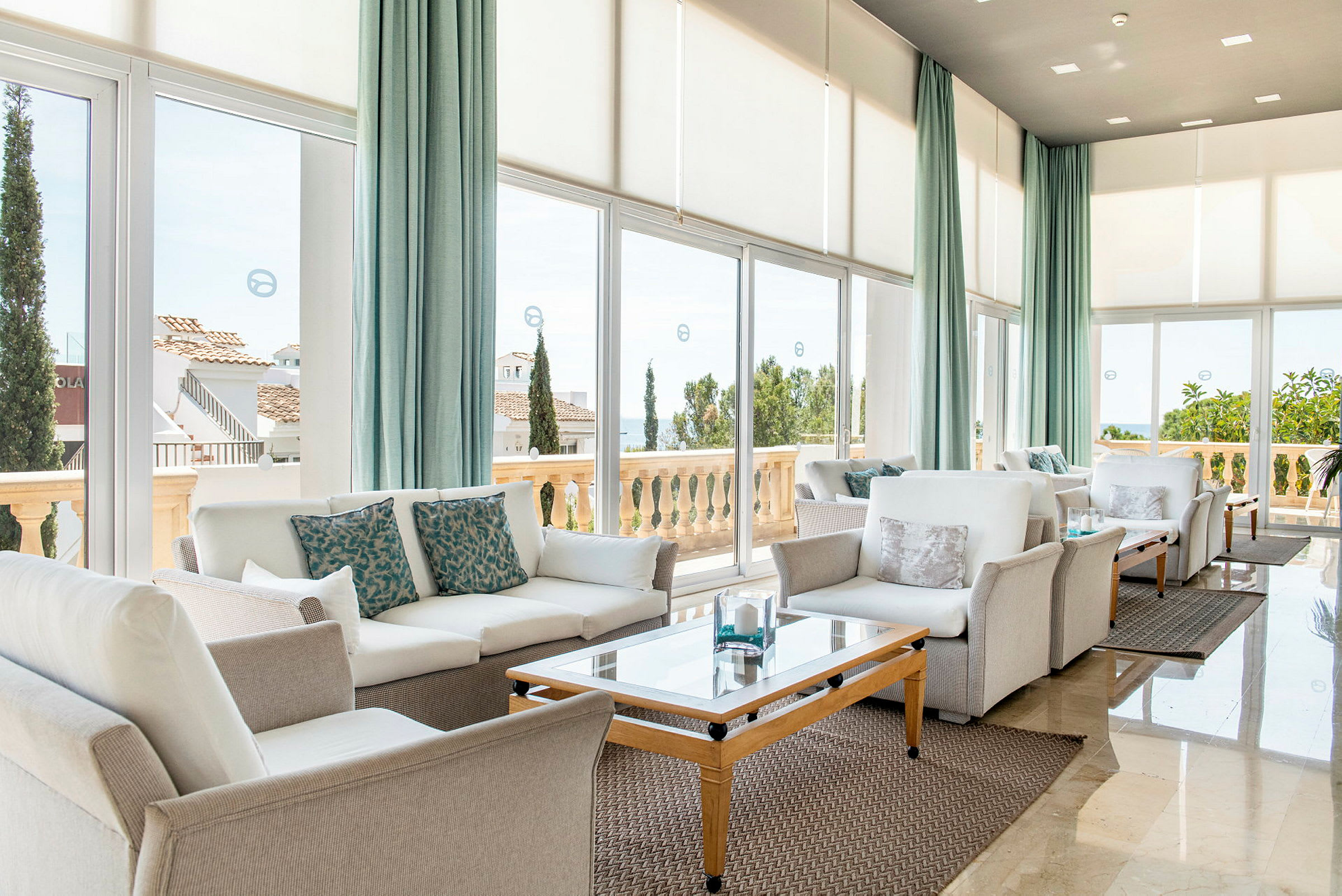 En lys lounge med moderne sofamøbler og store vinduer som vender mot en terrasse. (AI-generert tekst)