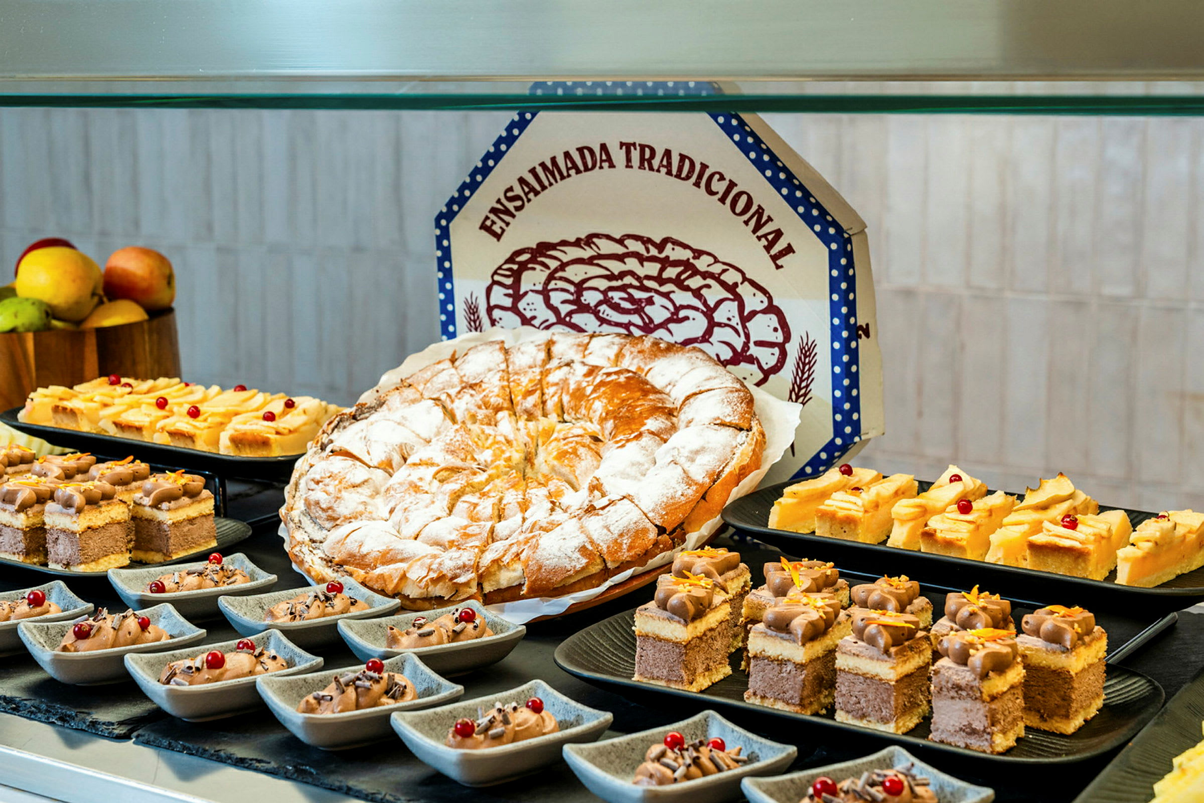 Et bord med forskjellige bakverk, inkludert en stor rund kake, små kakestykker og desserter i små skåler. (AI-generert tekst)