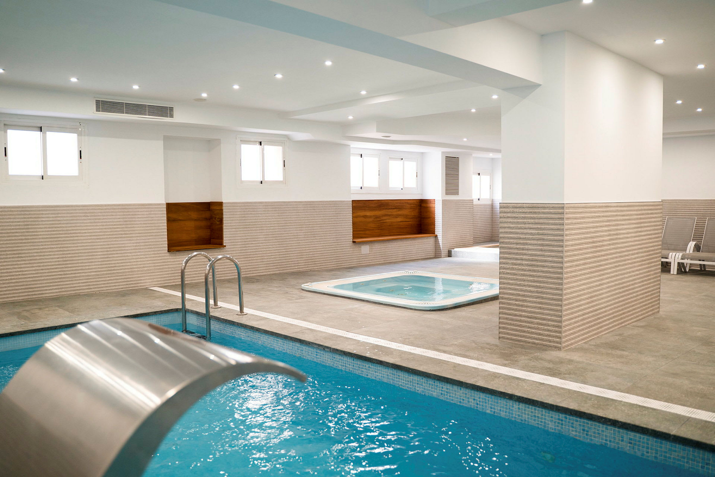 Innendørs spa med basseng og boblebad. (AI-generert tekst)