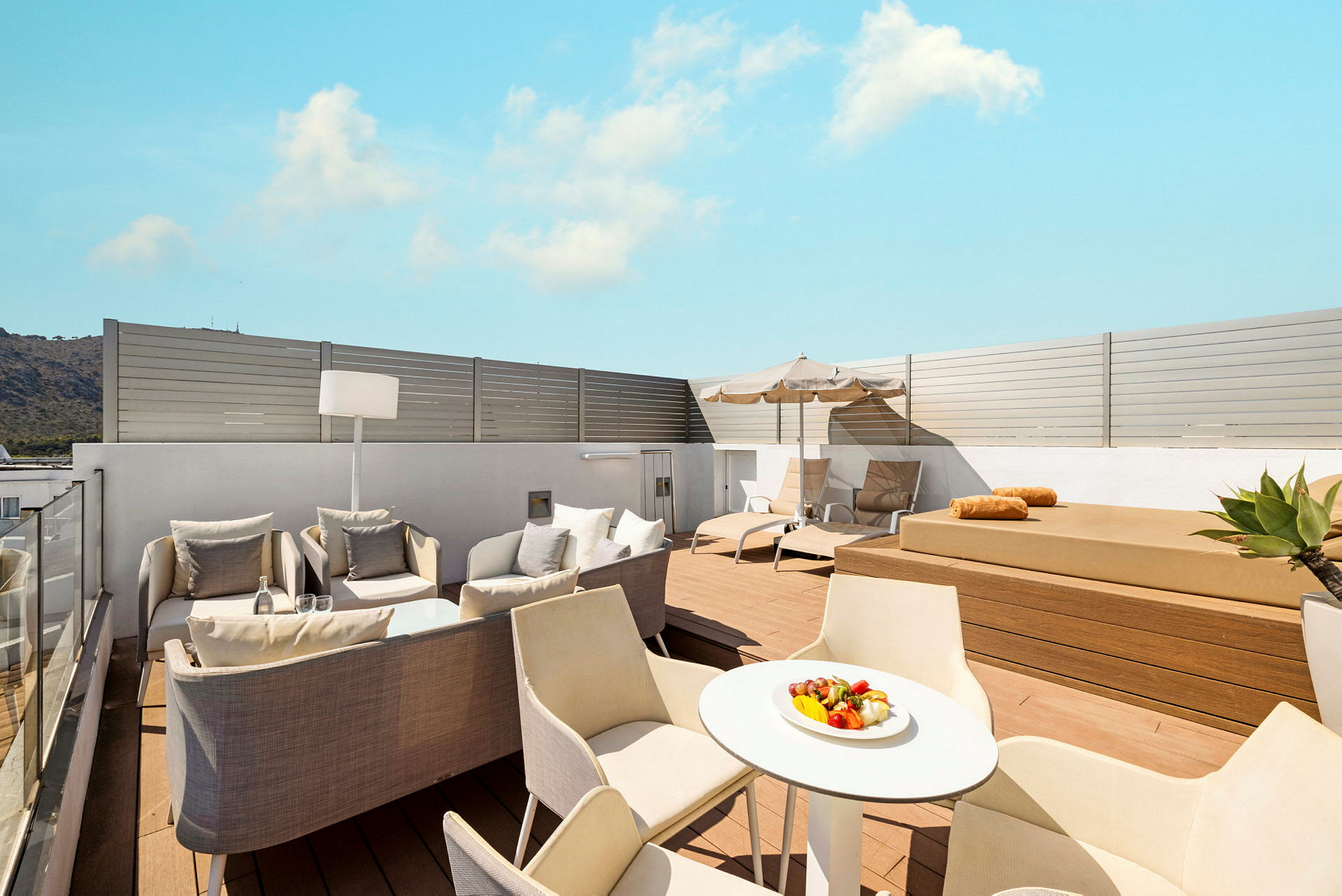 Moderne takterrasse med solsenger, sittegruppe og bord. (AI-generert tekst)