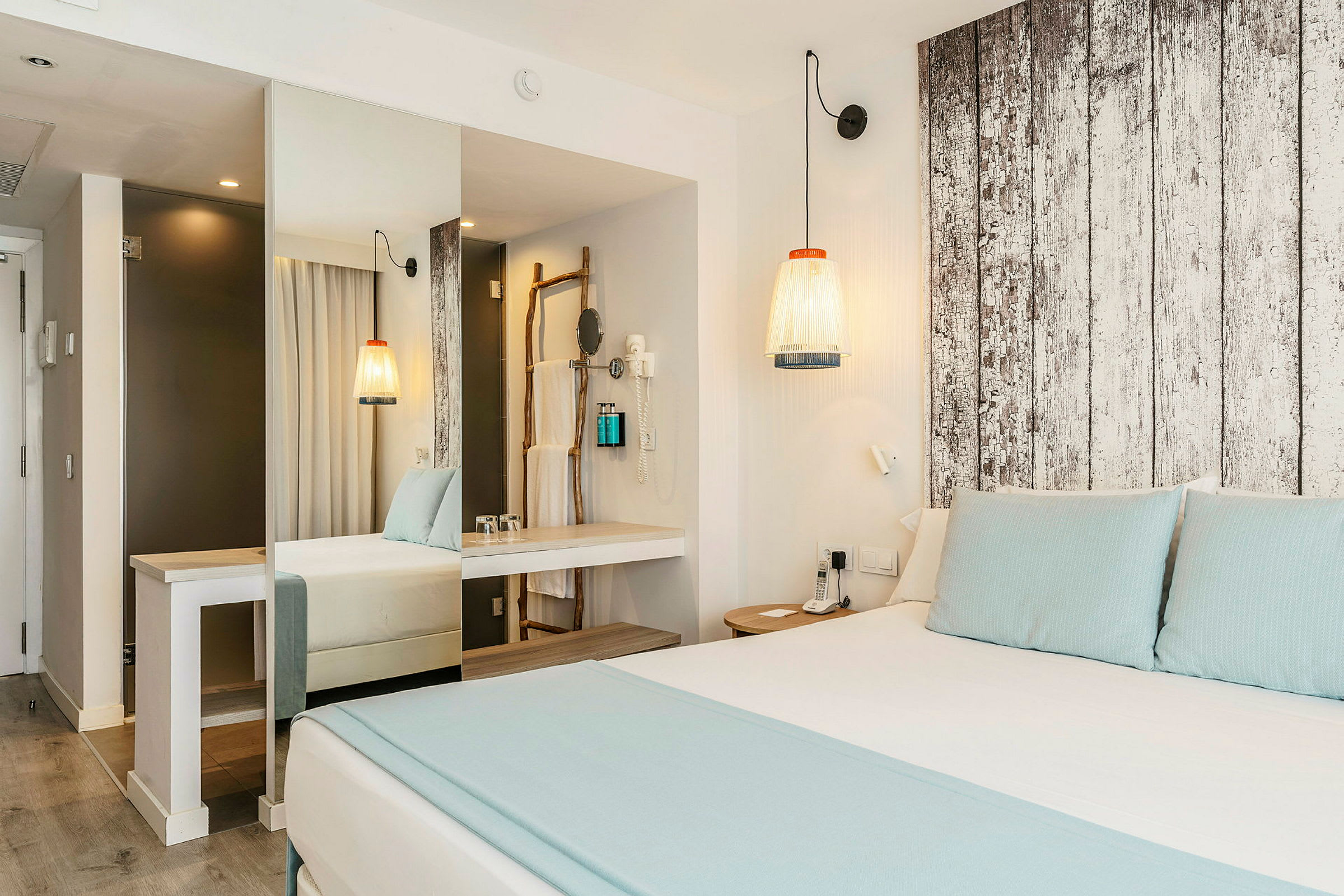Moderne hotellrom med dobbeltseng, lys innredning og tredetaljer. (AI-generert tekst)