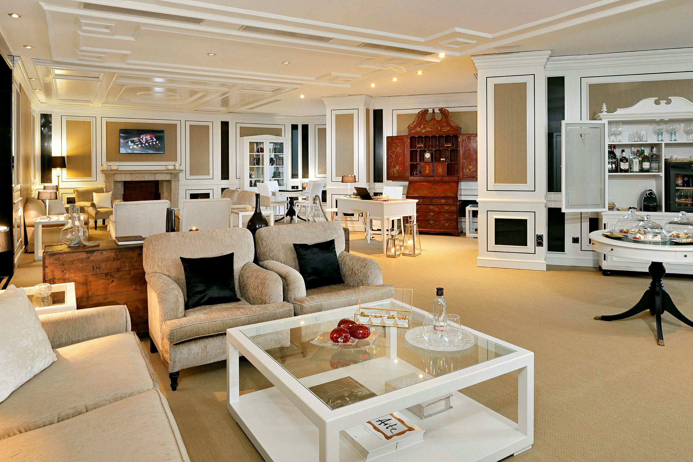 En elegant stue med komfortable sofaer, et glassbord og en peis i bakgrunnen. (AI-generert tekst)