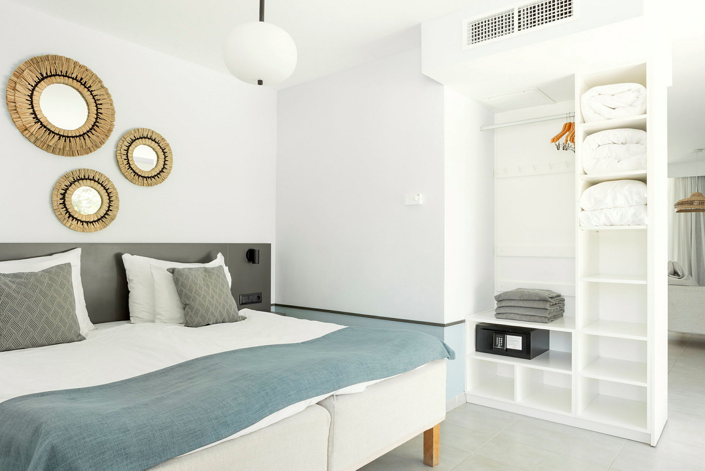 Moderne hotellrom med dobbeltseng og oppbevaring. (AI-generert tekst)