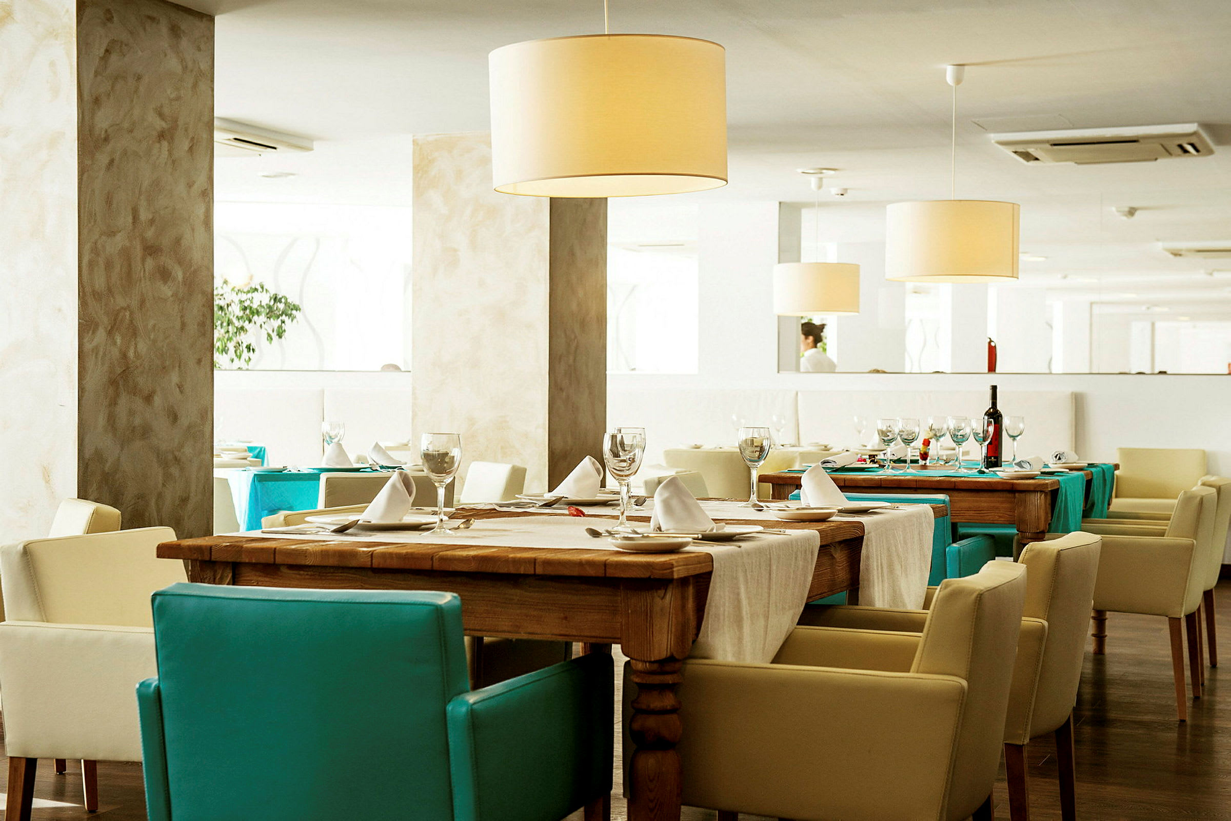 Et elegant restaurantinteriør med dekkede bord og lyse stoler. (AI-generert tekst)