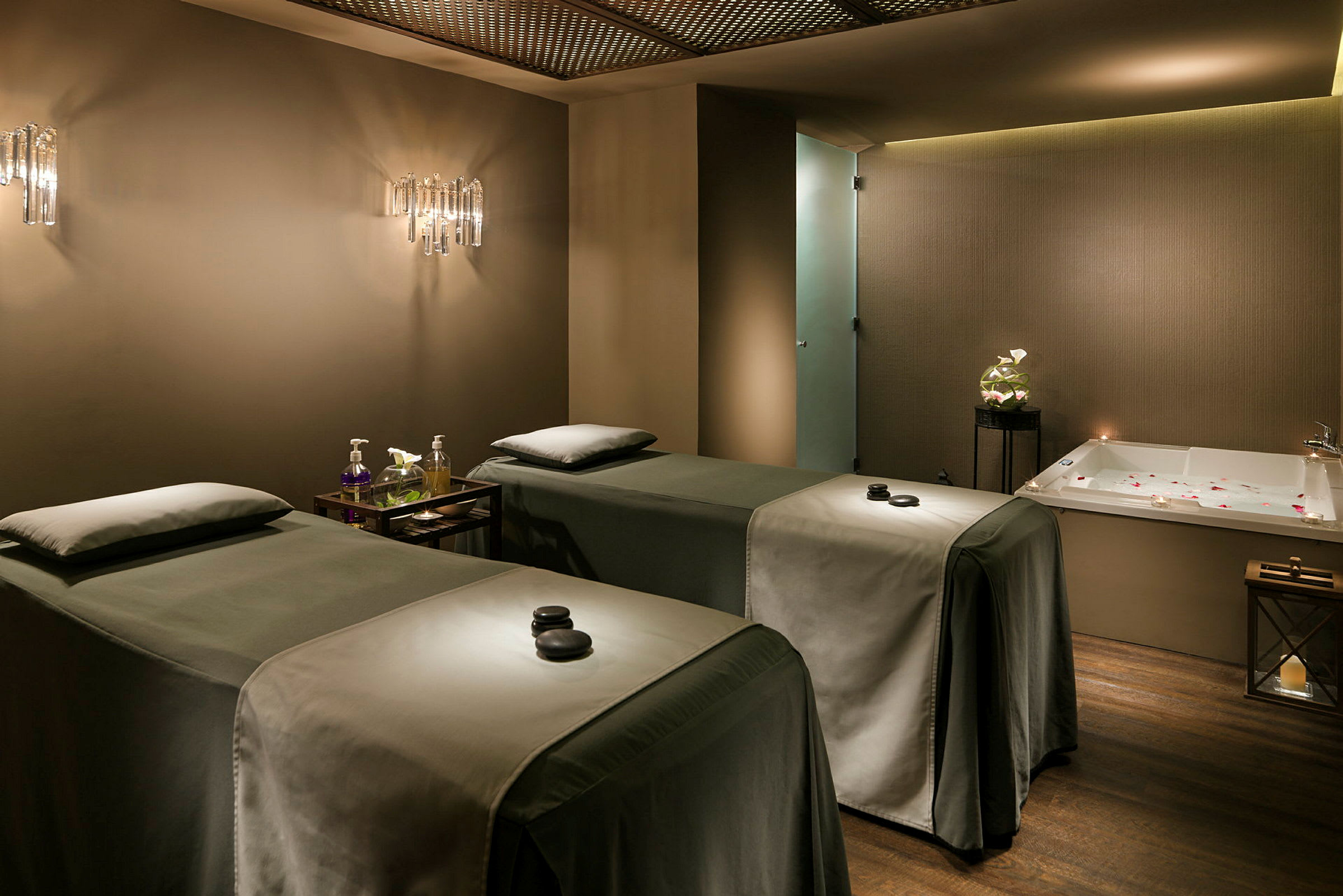 Et behandlingsrom på spa med to behandlingssenger og et badekar. (AI-generert tekst)