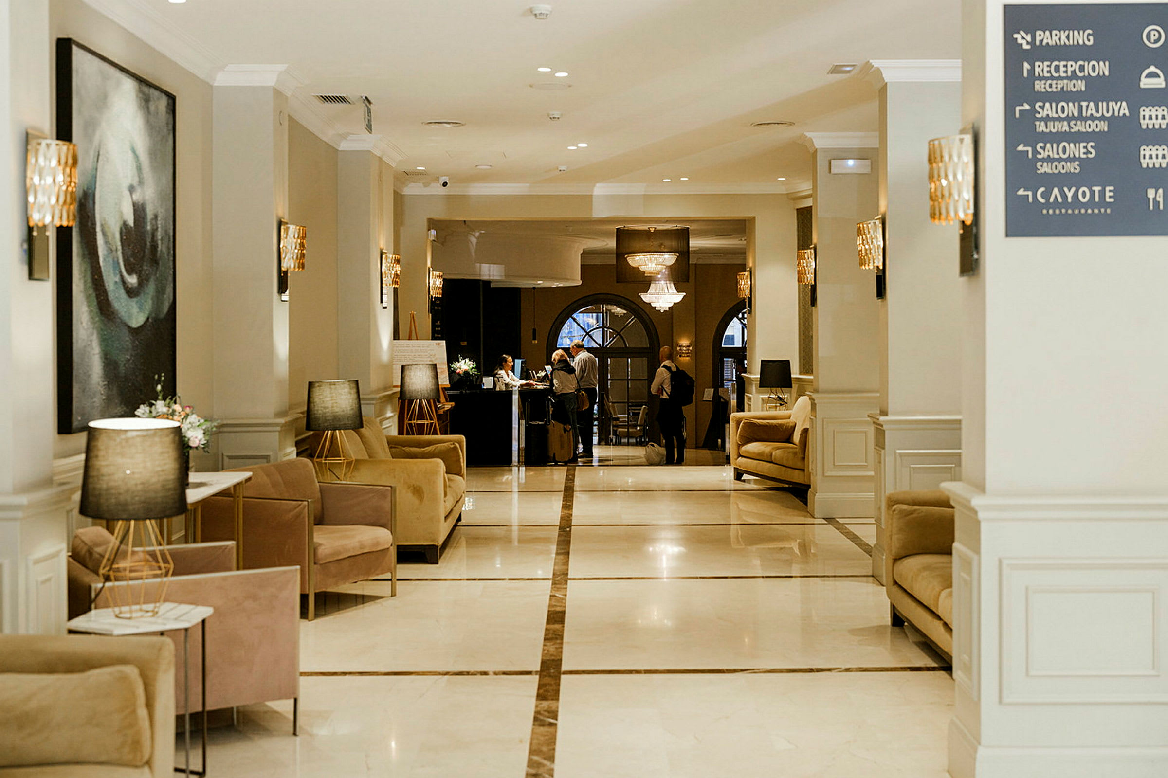 Bildet viser en hotellobby med elegante sittemøbler og en resepsjon i bakgrunnen. (AI-generert tekst)