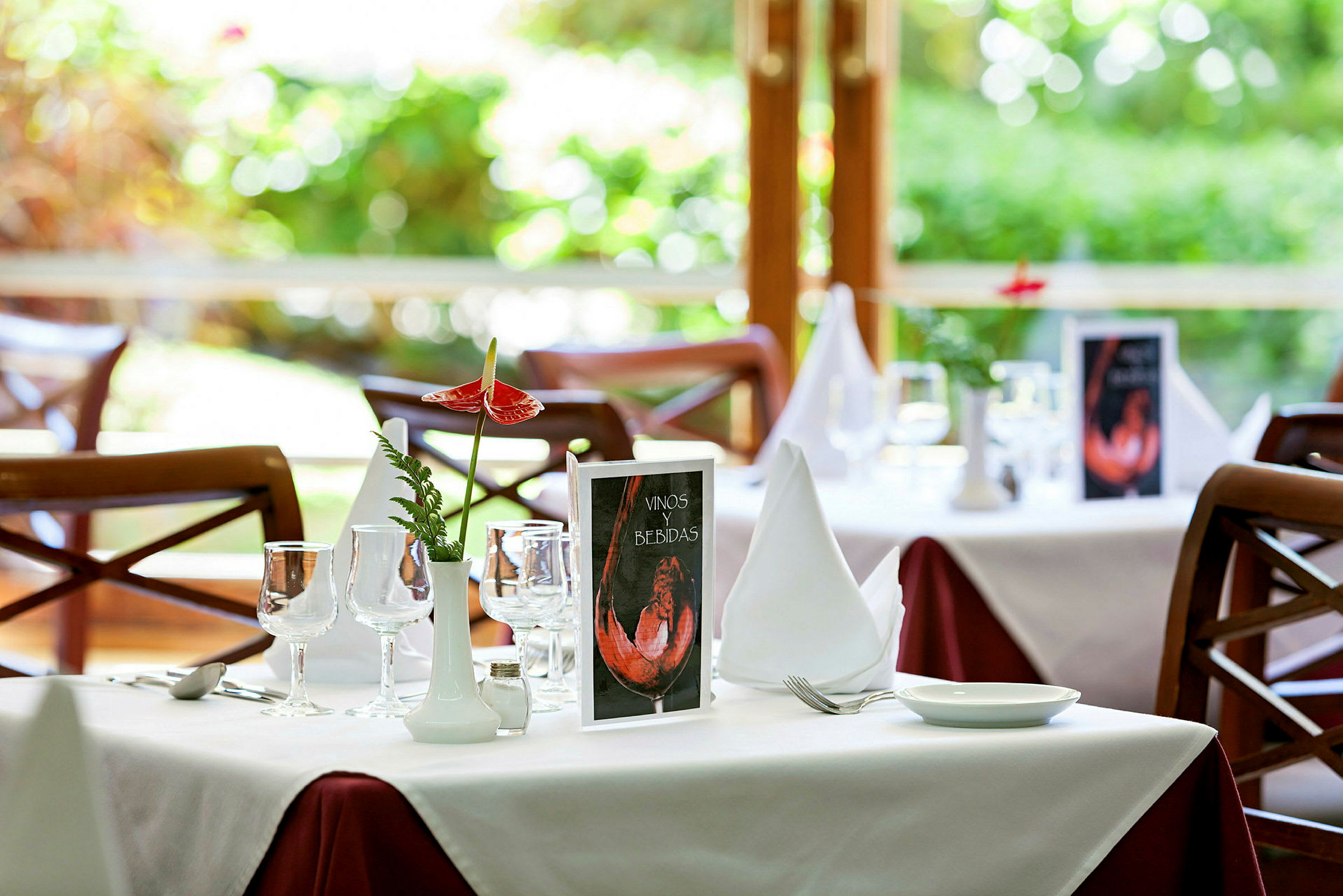 Et oppdekket bord i en restaurant med hvit duk og dekorasjoner. (AI-generert tekst)