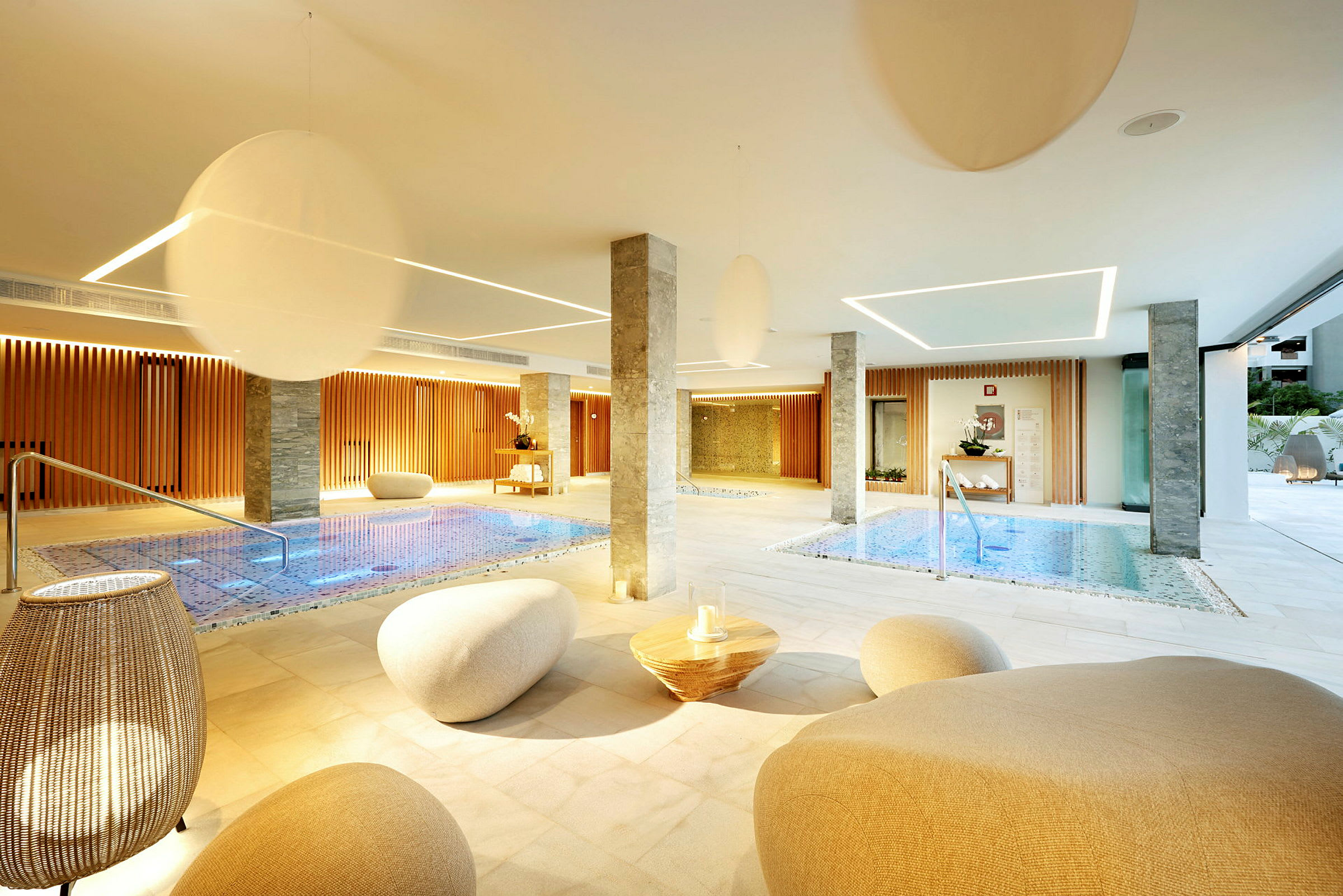 Et moderne spa med innendørs bassenger, sitteplasser og elegant belysning. (AI-generert tekst)