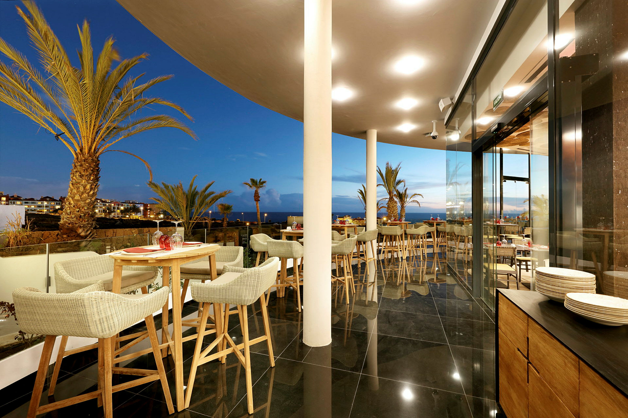 Terrasse med utsikt over palmer og havet. (AI-generert tekst)