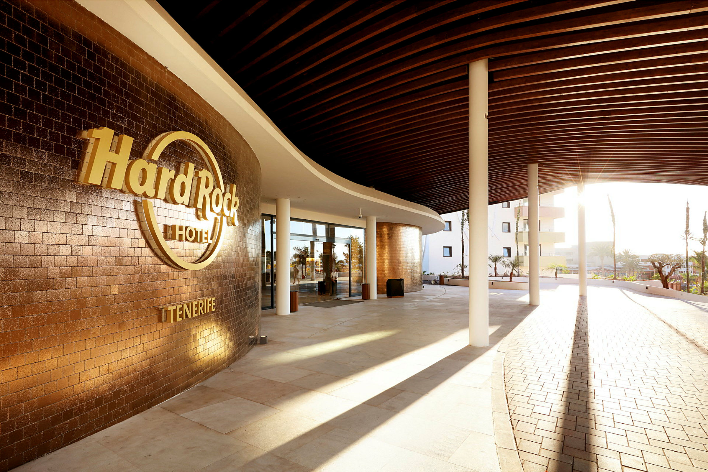 Inngangen til Hard Rock Hotel Tenerife med solskinn og moderne design. (AI-generert tekst)