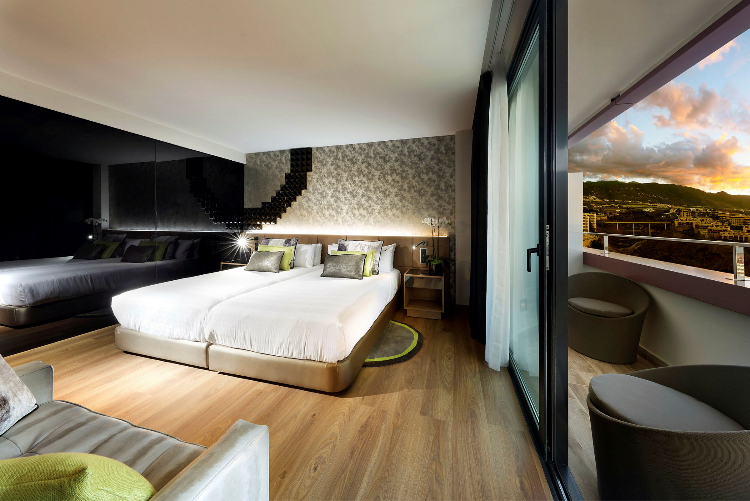Moderne hotellrom med to senger, en speilvegg og balkong med utsikt over landskapet. (AI-generert tekst)