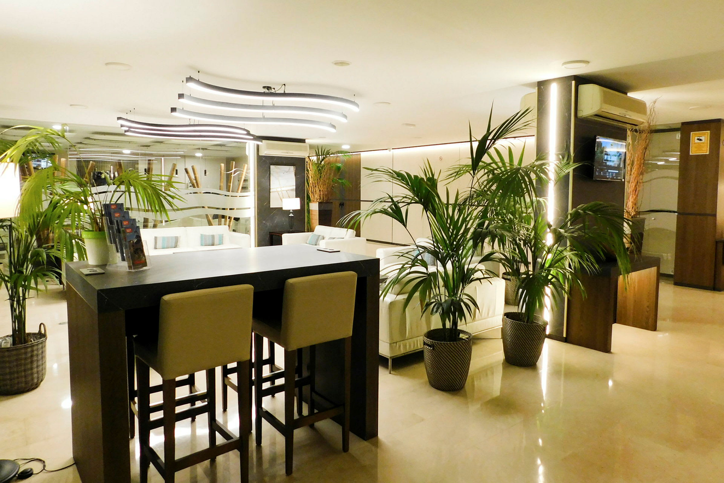 Hotellobby med moderne interiør, sofaer og planter. (AI-generert tekst)