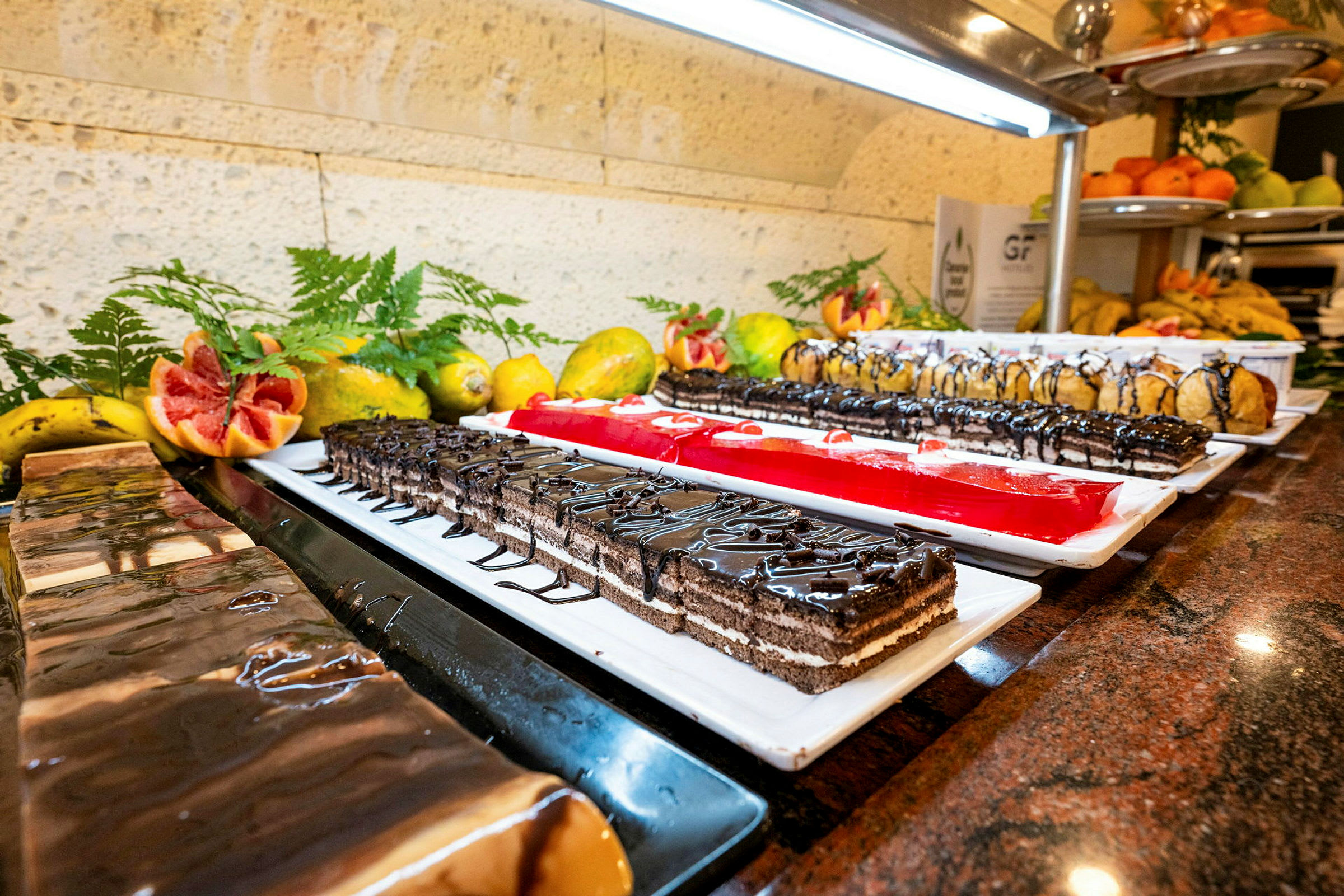 Buffetbord med ulike desserter, inkludert frukt og bakverk. (AI-generert tekst)