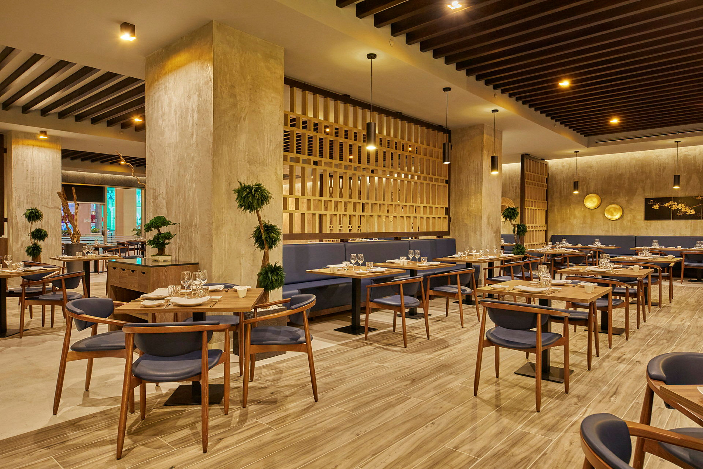 En moderne restaurant med treinteriør, bord med borddekning og blå stoler. (AI-generert tekst)