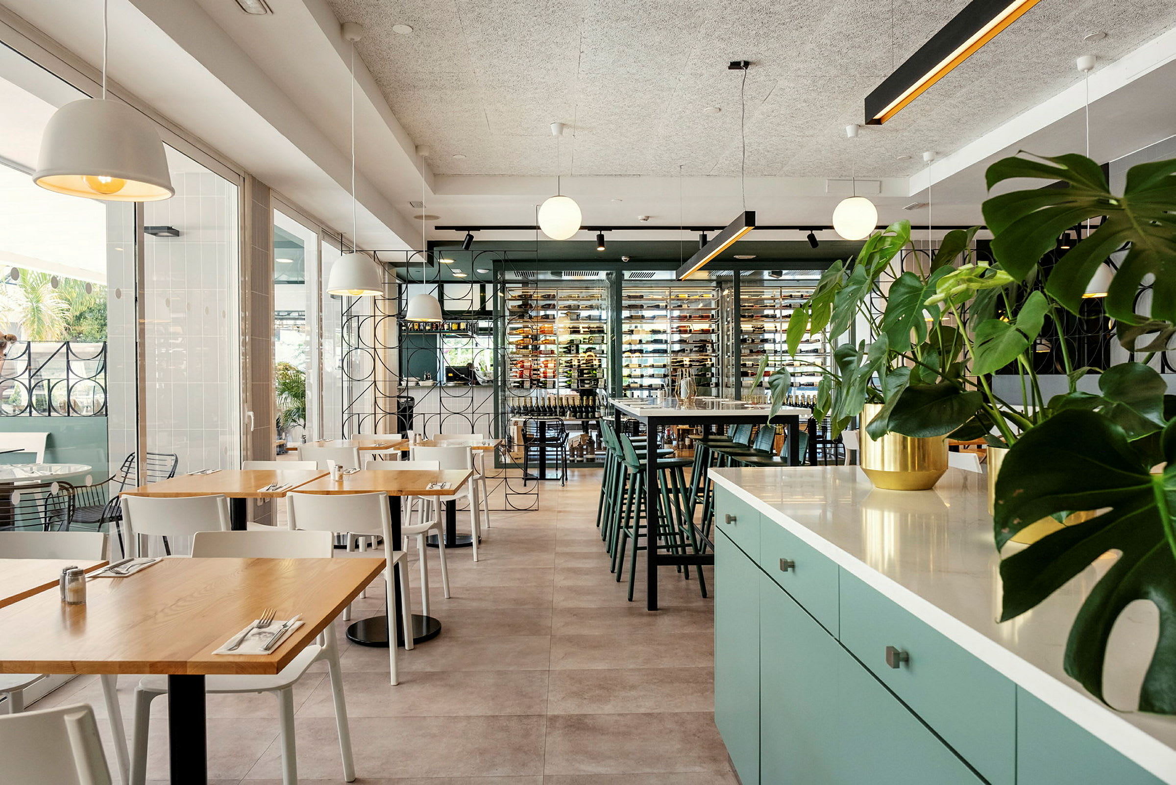 Interiør av en moderne restaurant med sittegrupper og grønne planter. (AI-generert tekst)