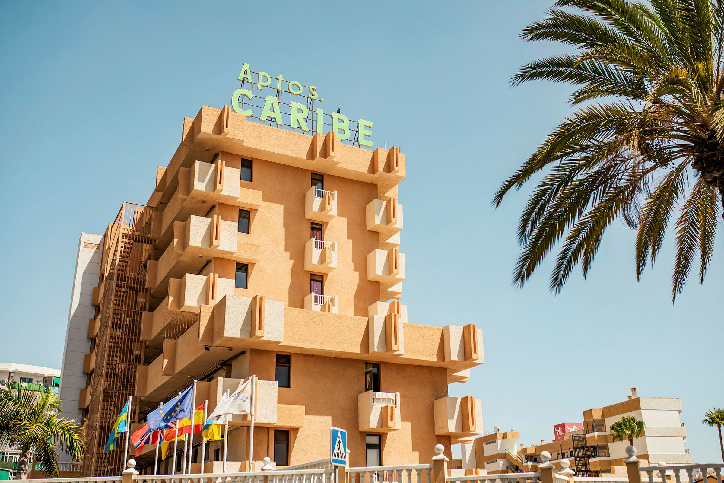 Oransje bygning med skilt som sier 'Aptos Caribe'. (AI-generert tekst)