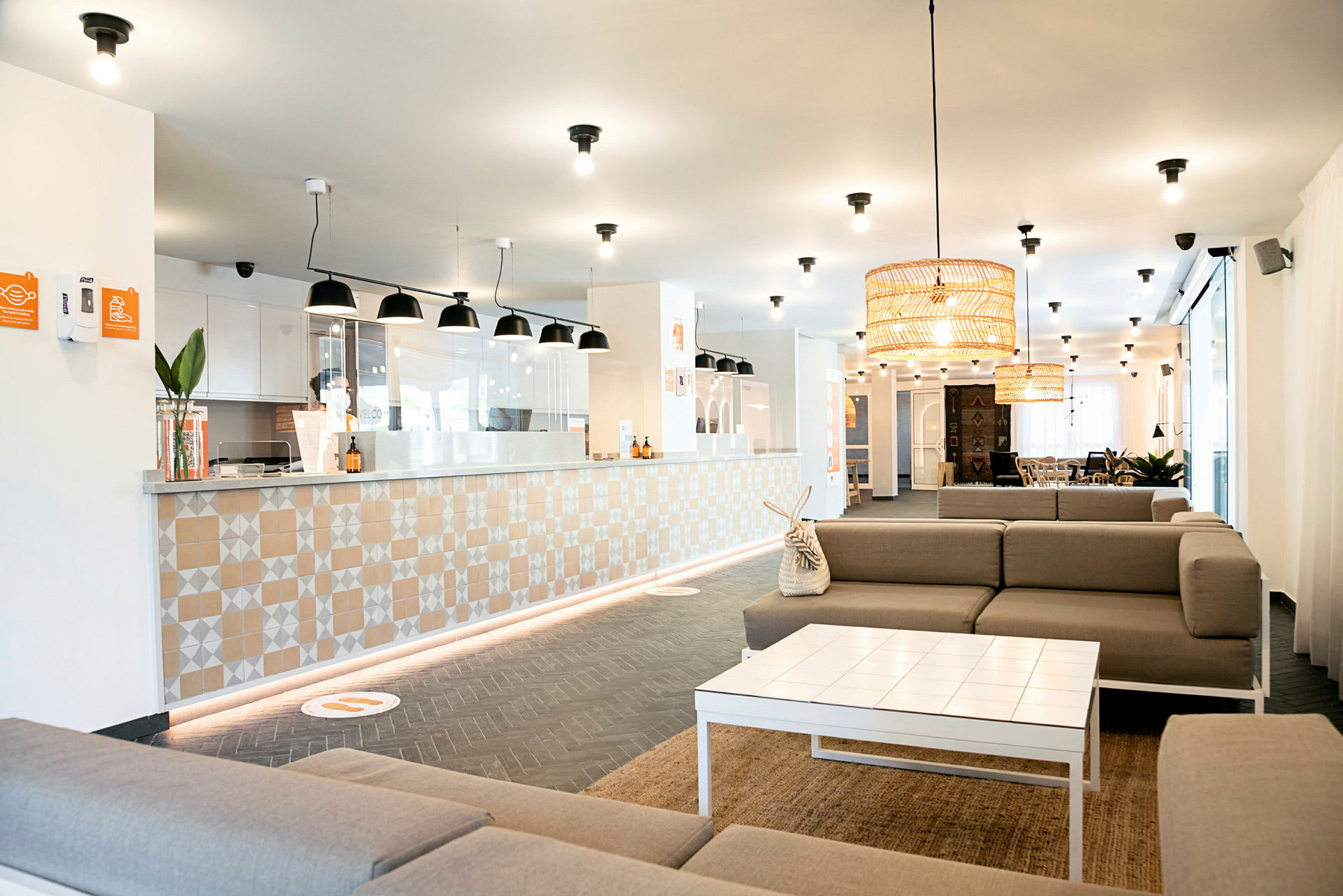 En moderne hotellobby med resepsjonsdisk og sitteområder. (AI-generert tekst)