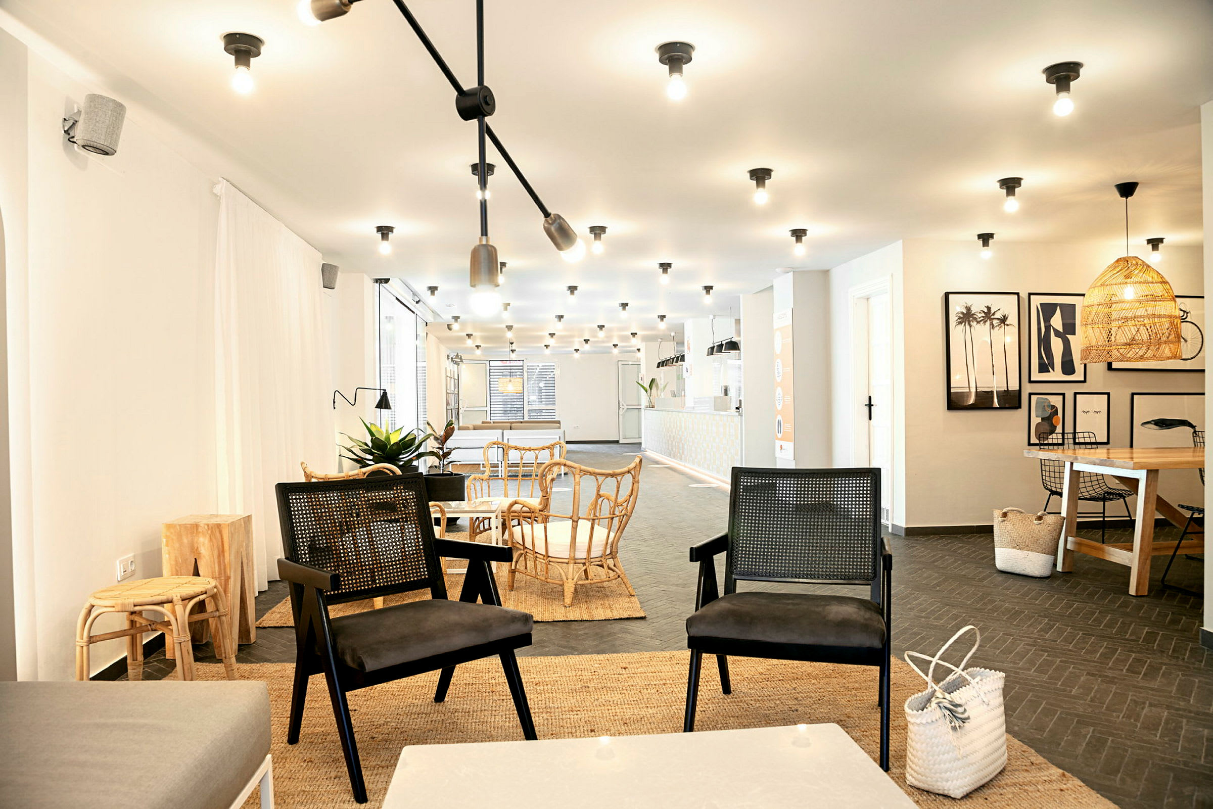 En moderne innredet lounge med bord og stoler i et lyst miljø. (AI-generert tekst)