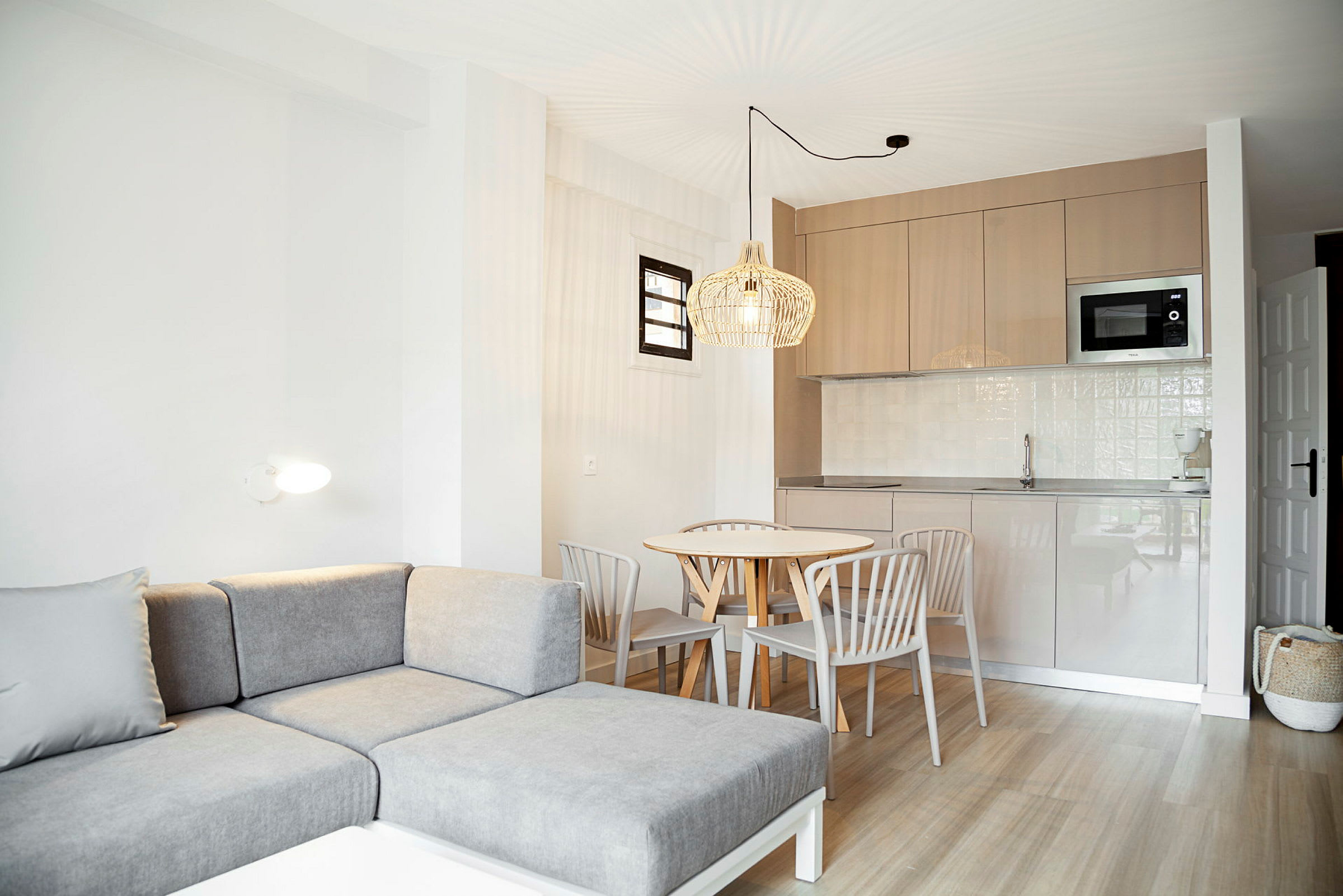 En lys leilighet med moderne sofa, spisebord og kjøkken. (AI-generert tekst)