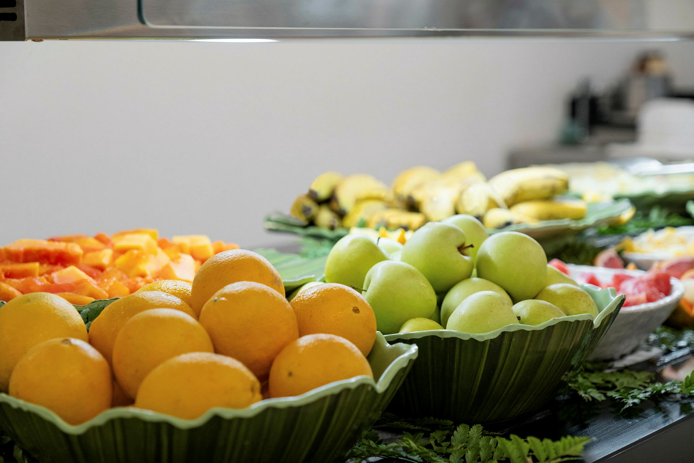 En buffet med forskjellige frukter som appelsiner, grønne epler og bananer. (AI-generert tekst)