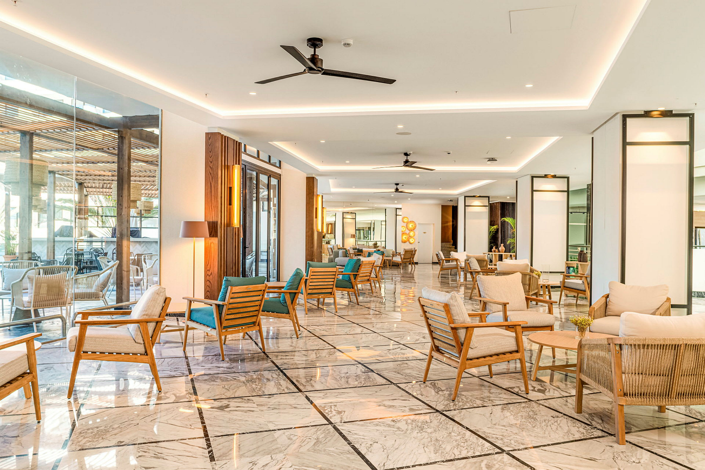 Et moderne hotellobbyområde med sofaer og lenestoler i nøytrale farger kombinert med tregulv og lyse overflater. (AI-generert tekst)