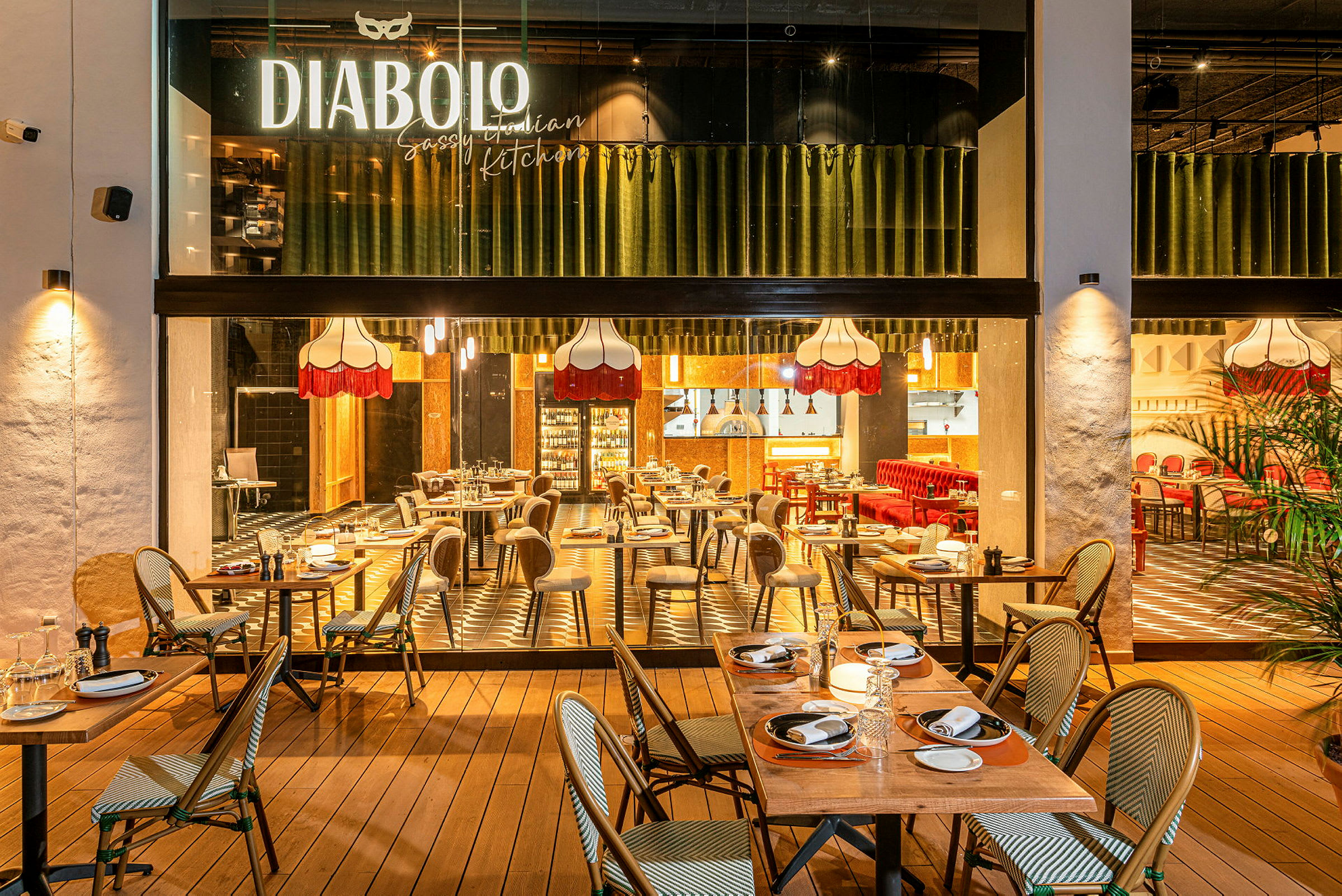 Et restaurantmiljø med oppdekkede bord og elegant belysning, både innendørs og utendørs. (AI-generert tekst)