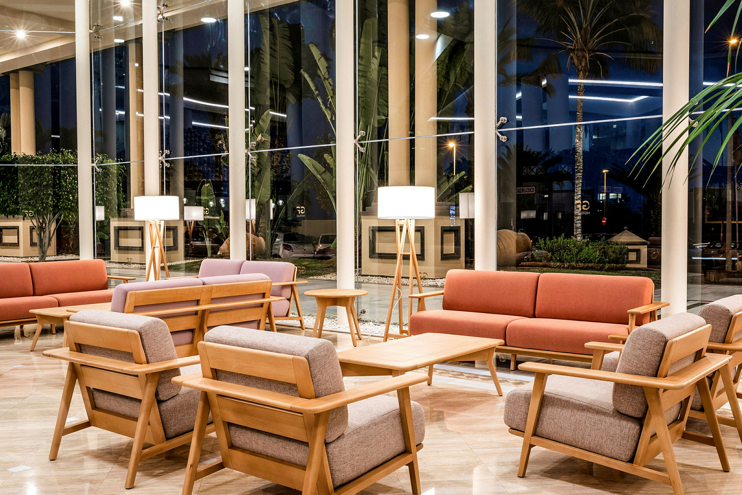 En hotellobby med moderne møbler og store vinduer. (AI-generert tekst)