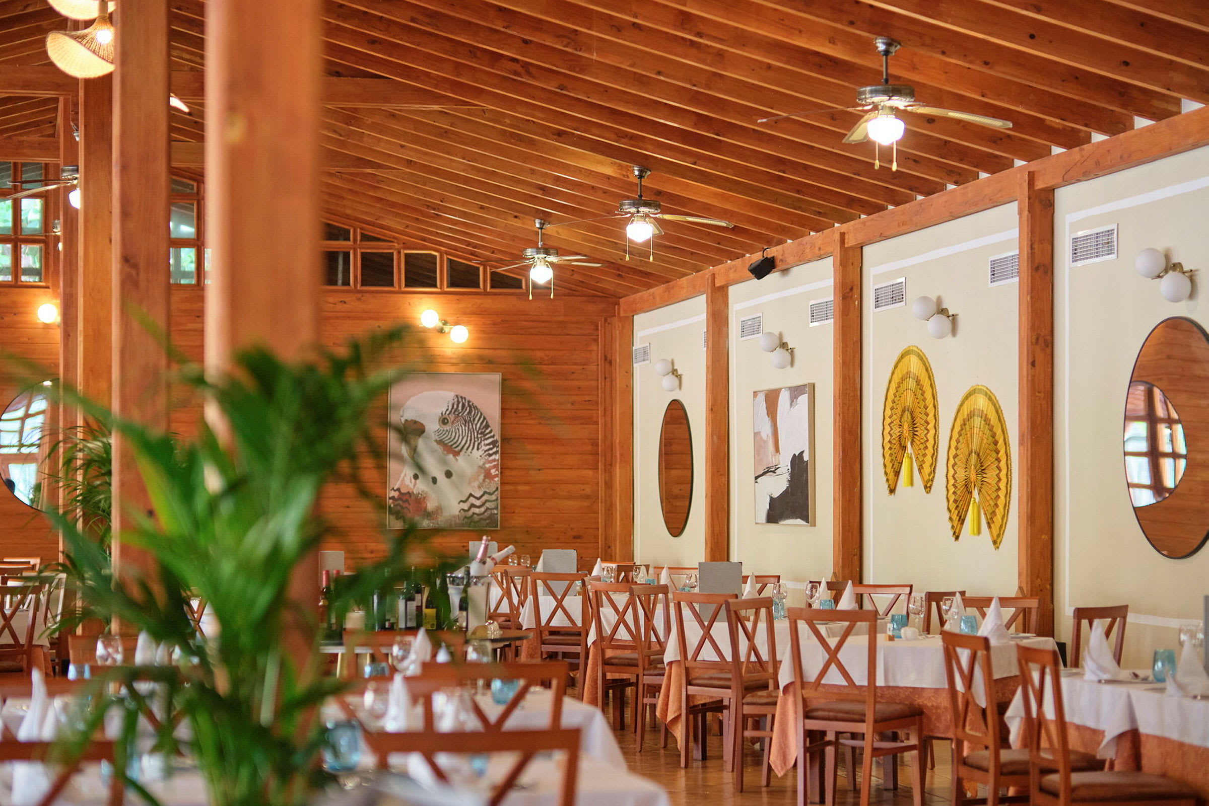 Interiør av en restaurant med dekkede bord og treinteriør. (AI-generert tekst)
