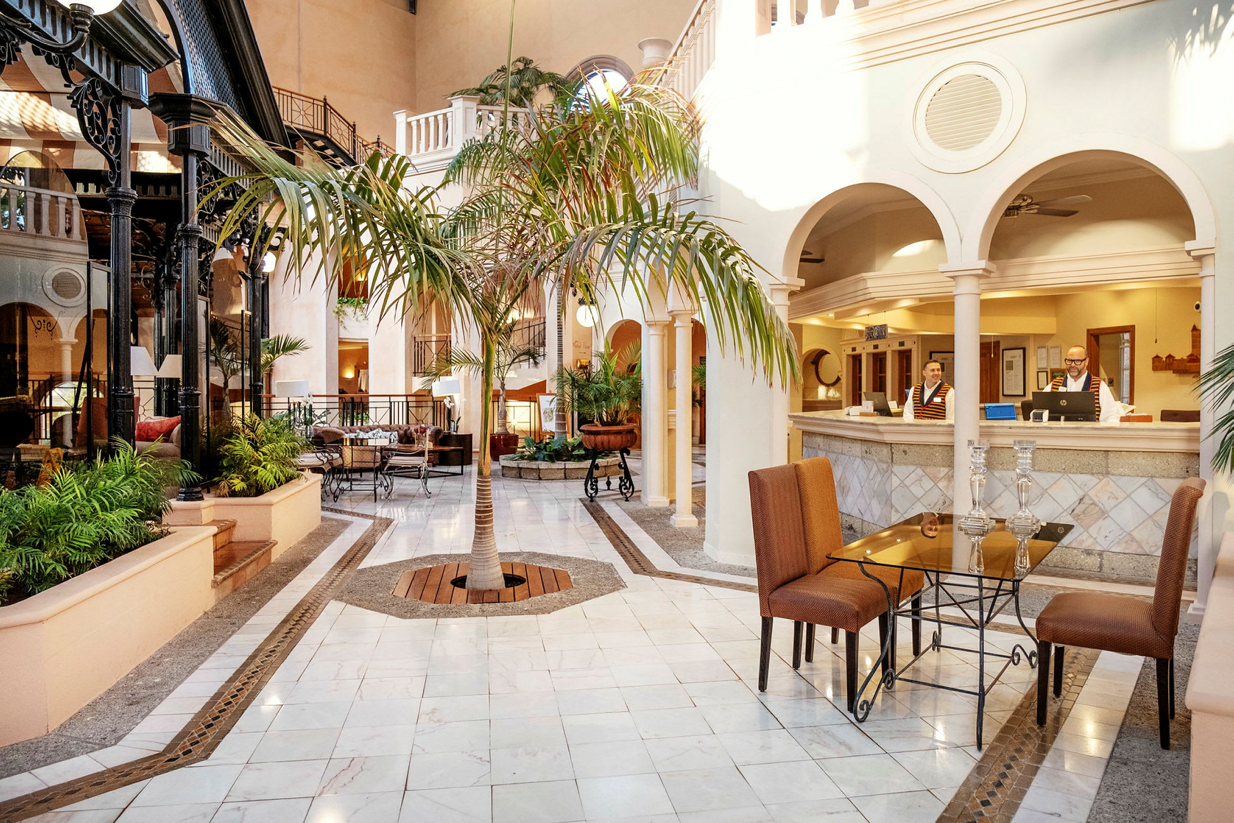 Hotellets lobby med marmorgulv, sittegrupper og en sentral palme. (AI-generert tekst)