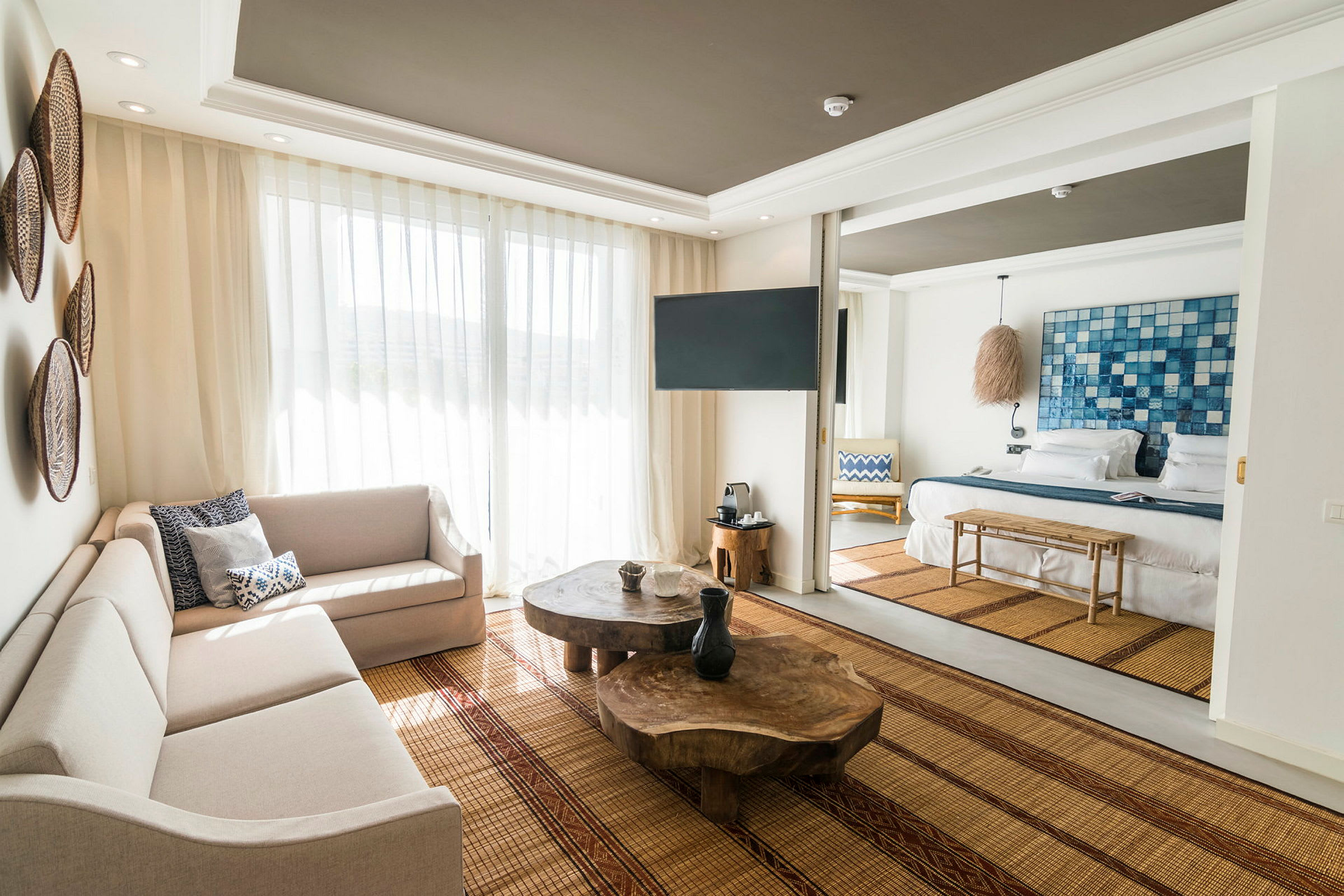 Bilde av et lyst og moderne hotellrom med stuemøbler og en seng. (AI-generert tekst)