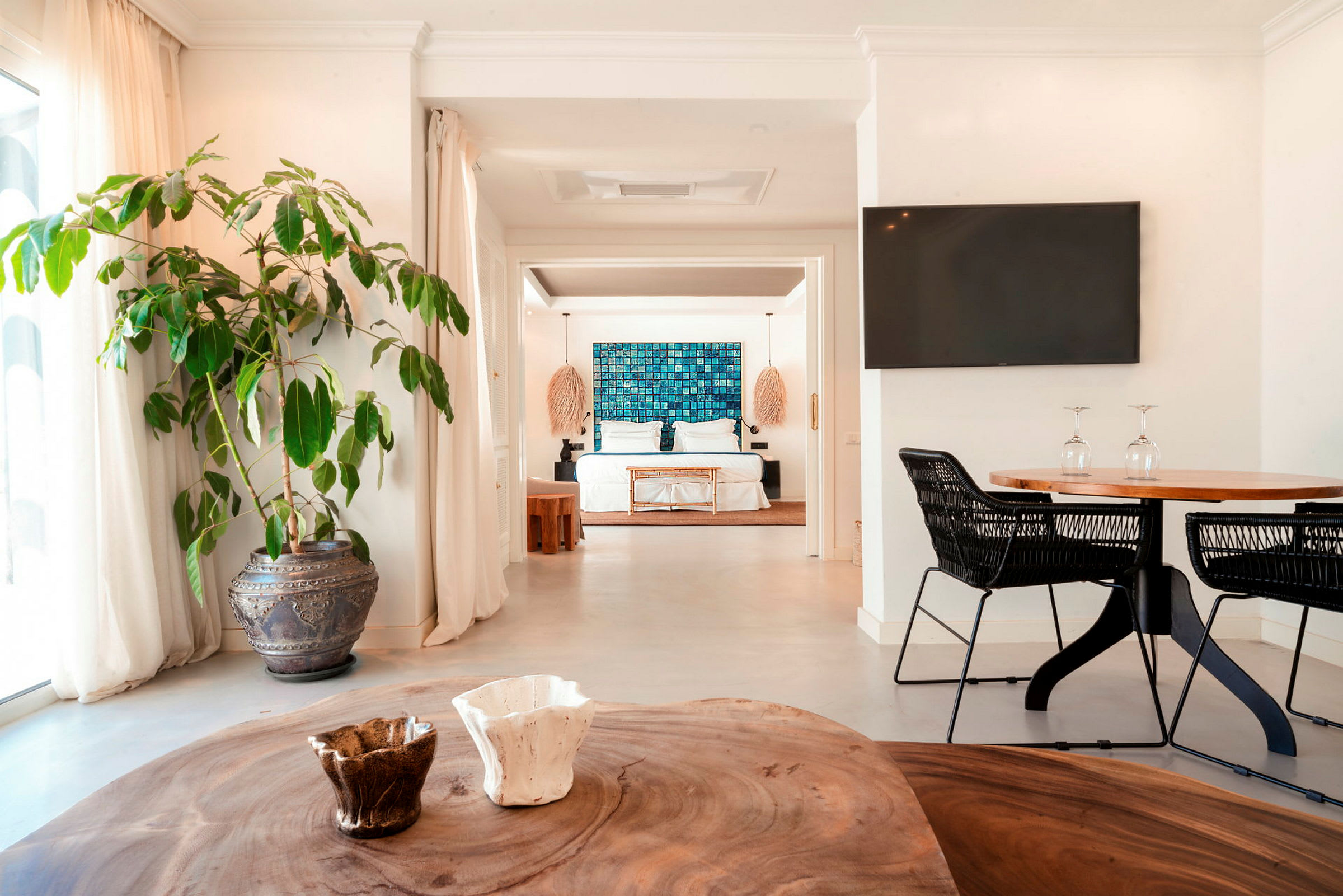 Et lyst og moderne hotellrom med en stor seng, dekorert med blå kunst på veggen og omgitt av elegante møbler. (AI-generert tekst)