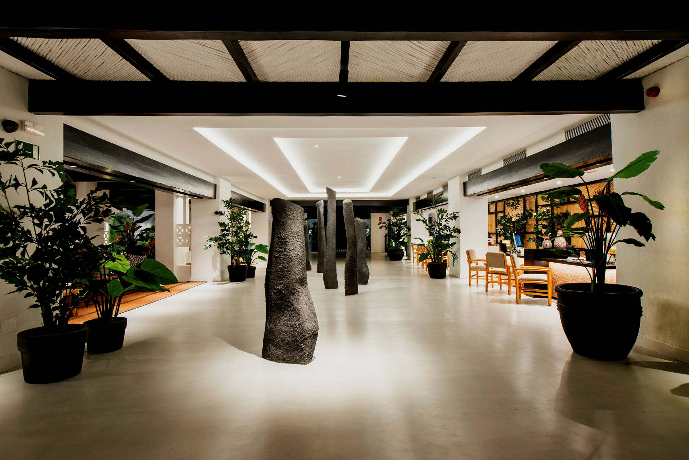Lys lobby med planter og dekorative steiner. (AI-generert tekst)