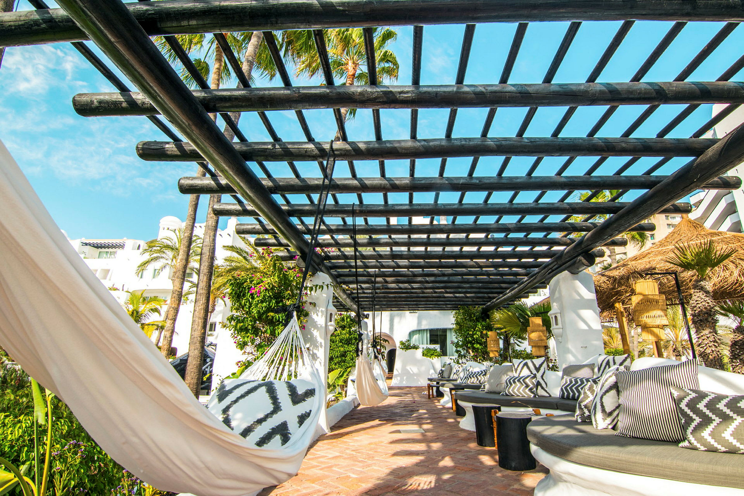 Utendørsområde med pergola, hengekøyer og sitteplasser. (AI-generert tekst)