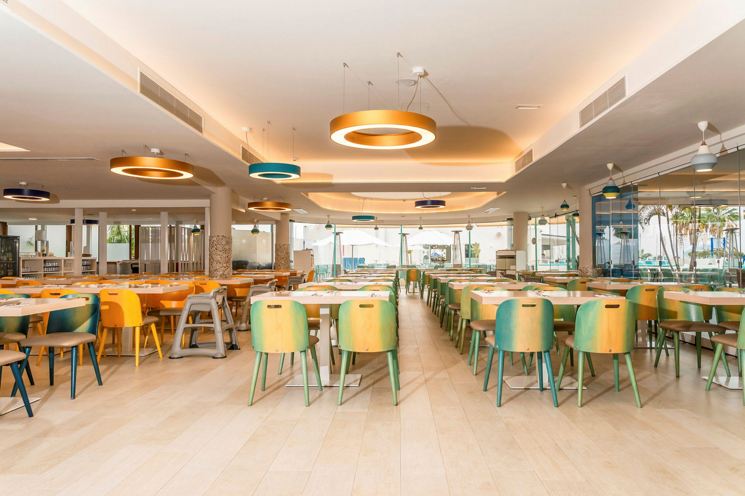 Restaurant med flere fargerike stoler og bord, moderne belysning. (AI-generert tekst)