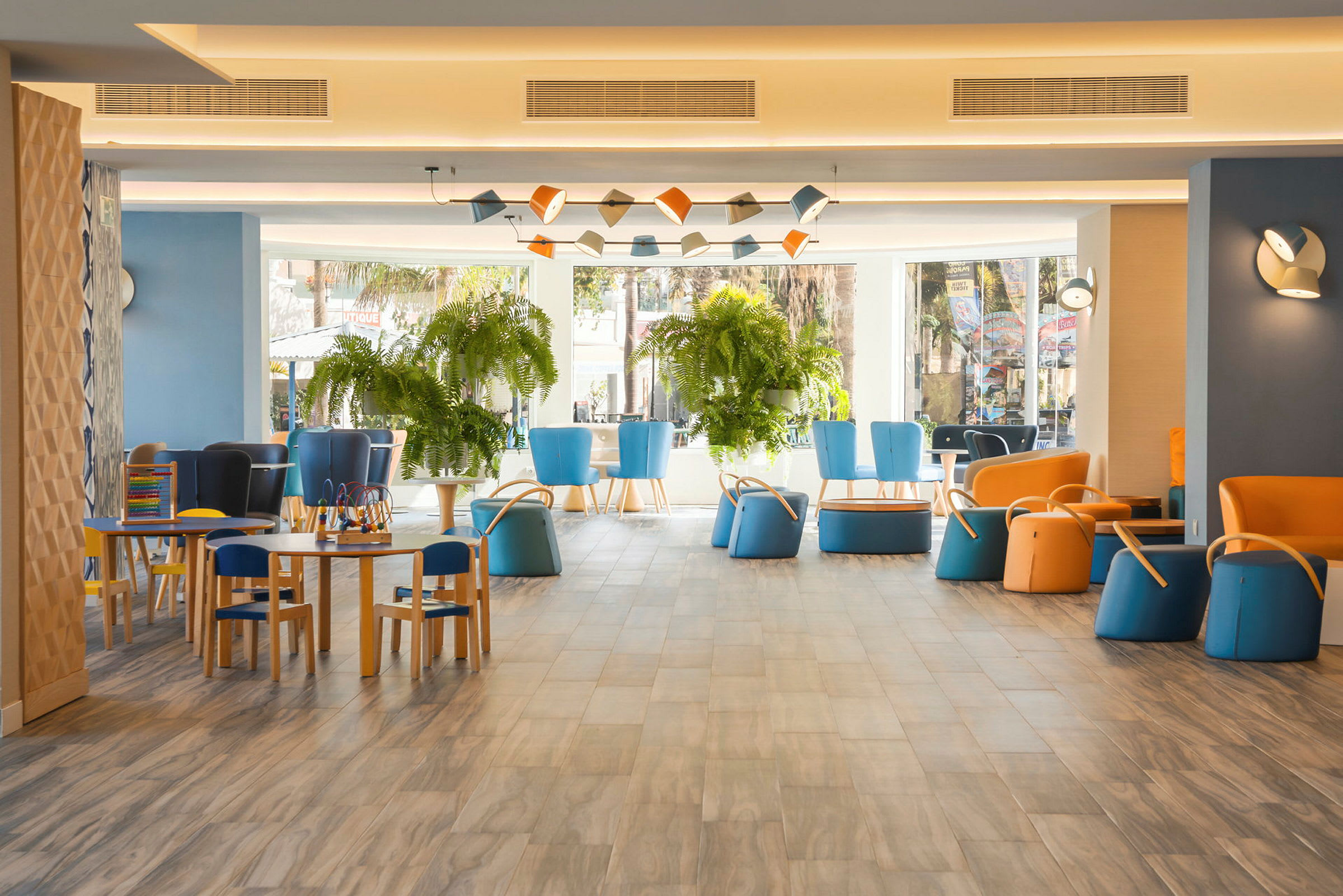 Et fargerikt hotellområde med sitteplasser og planter. (AI-generert tekst)