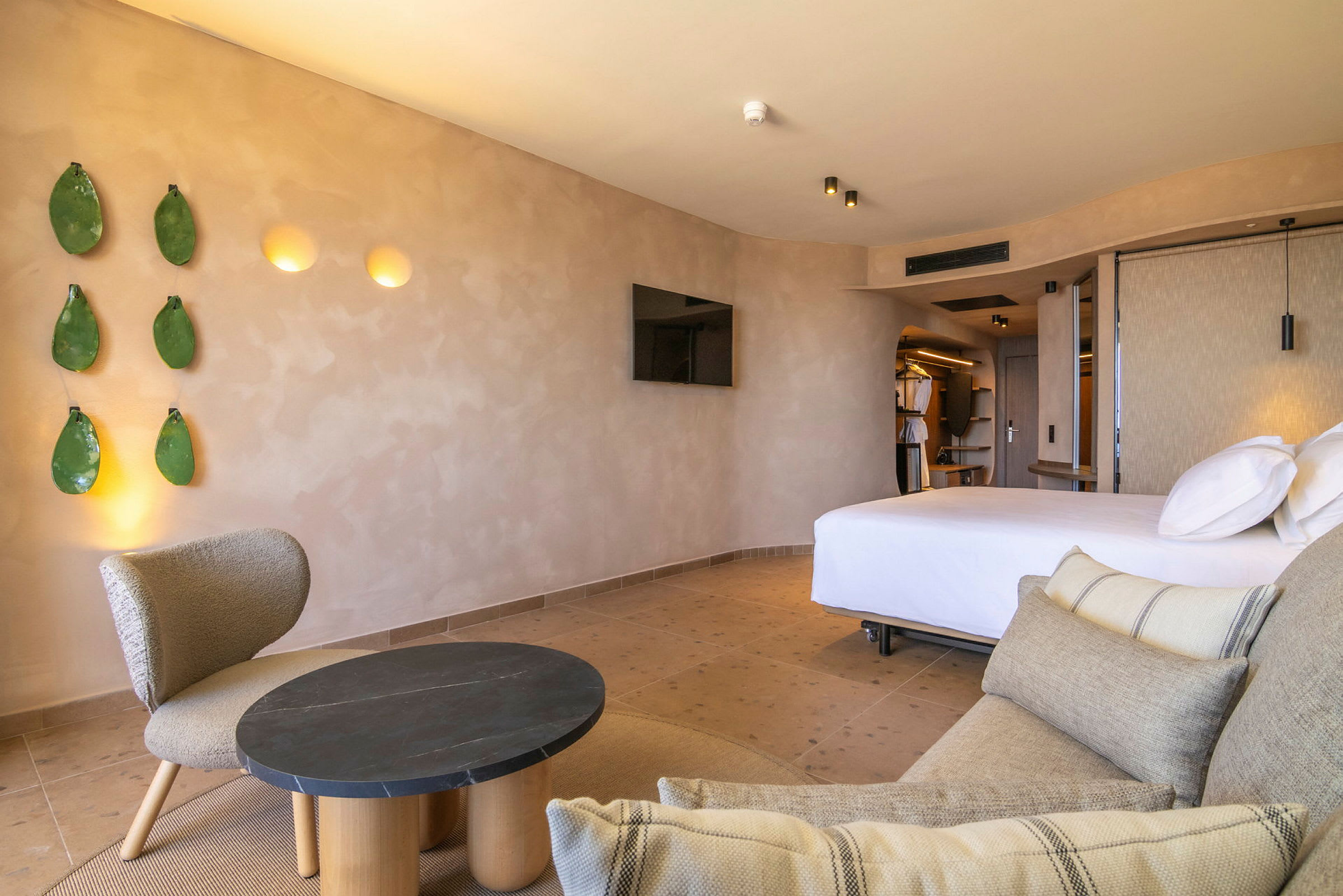 Bilde av et hotellrom med moderne innredning, inkludert en seng, en sofa og en lenestol. (AI-generert tekst)