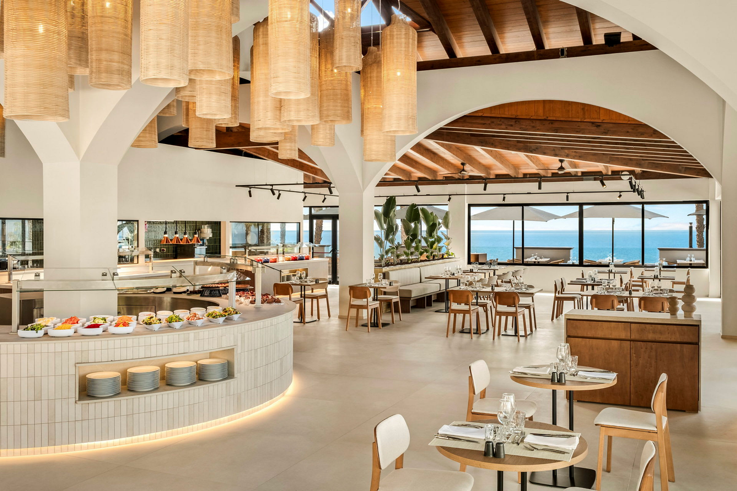 En moderne restaurant med åpent kjøkken og vinduer med havutsikt. (AI-generert tekst)
