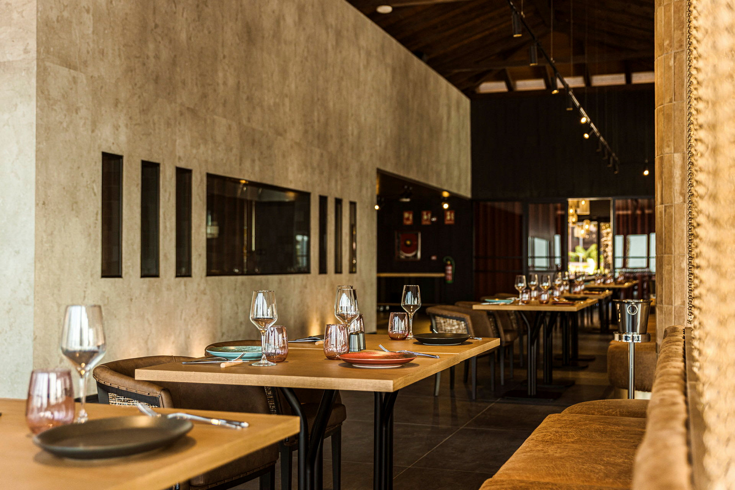 Et moderne og elegant innredet restaurantinteriør, med dekkede bord og stoler arrangert i en varm atmosfære. (AI-generert tekst)