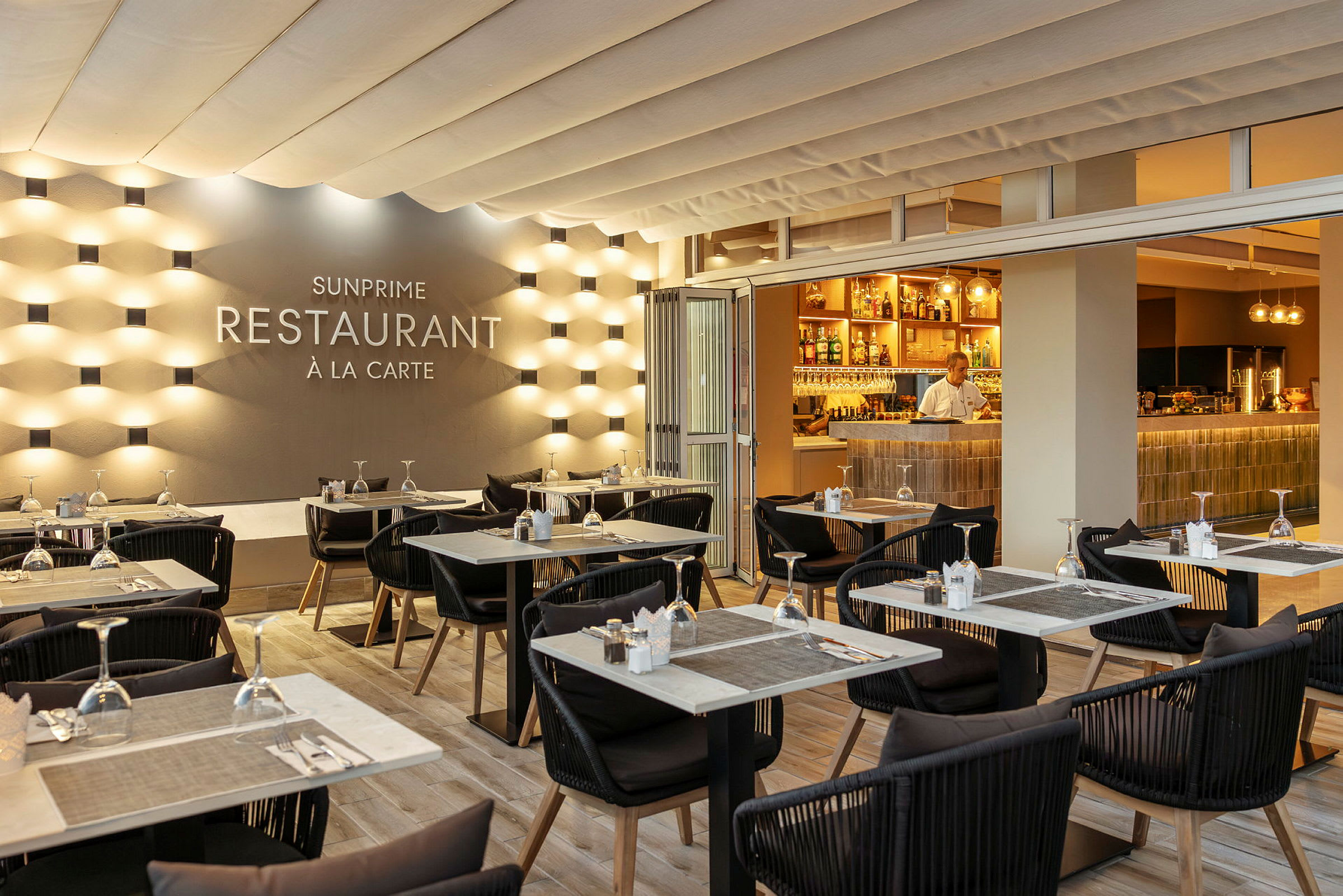En elegant restaurantlokale med dekkede bord og en opplyst bar. (AI-generert tekst)
