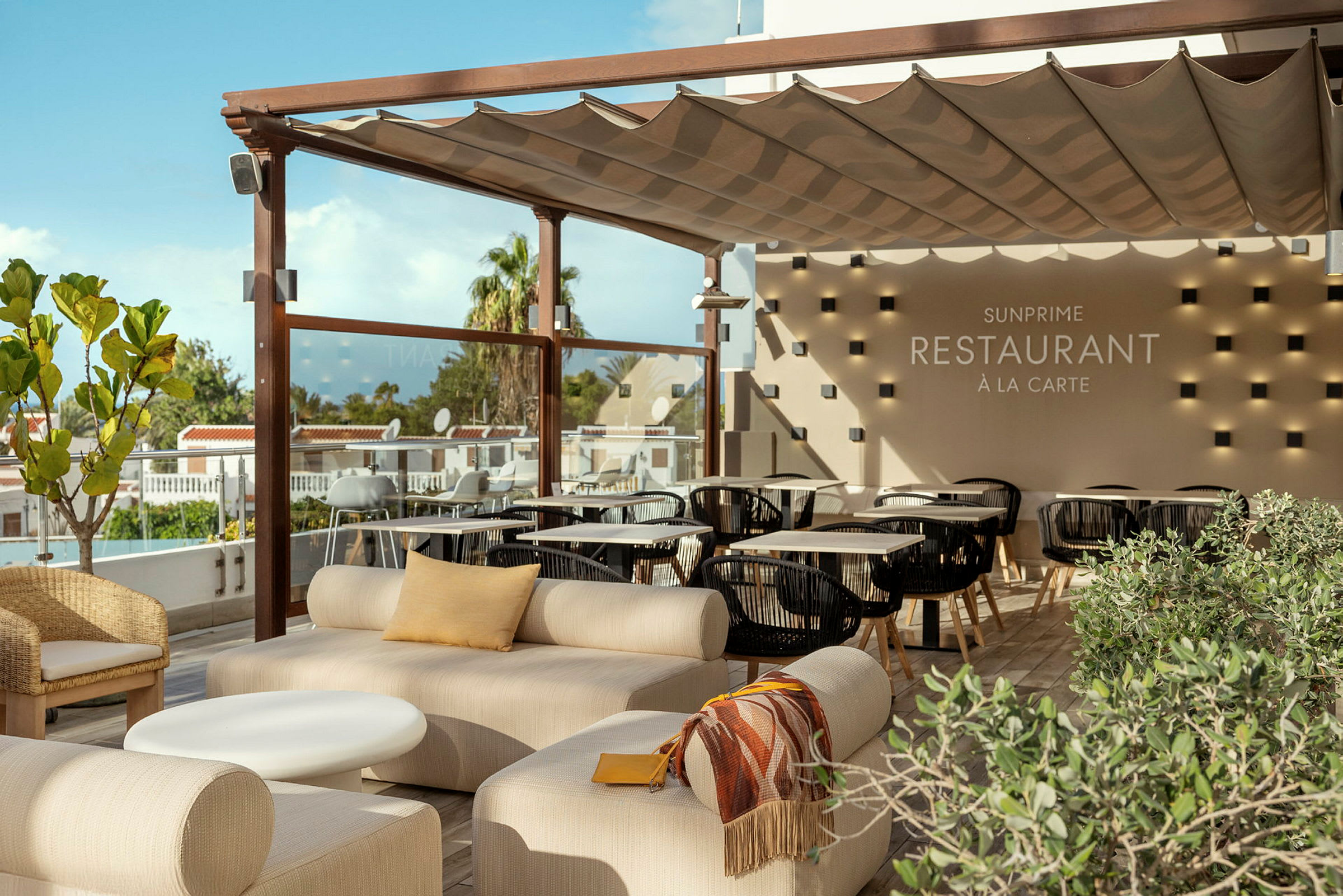 Et utendørsområde med sitteplasser og beskyttende tak, med synlig tekst som viser restaurantens navn. (AI-generert tekst)