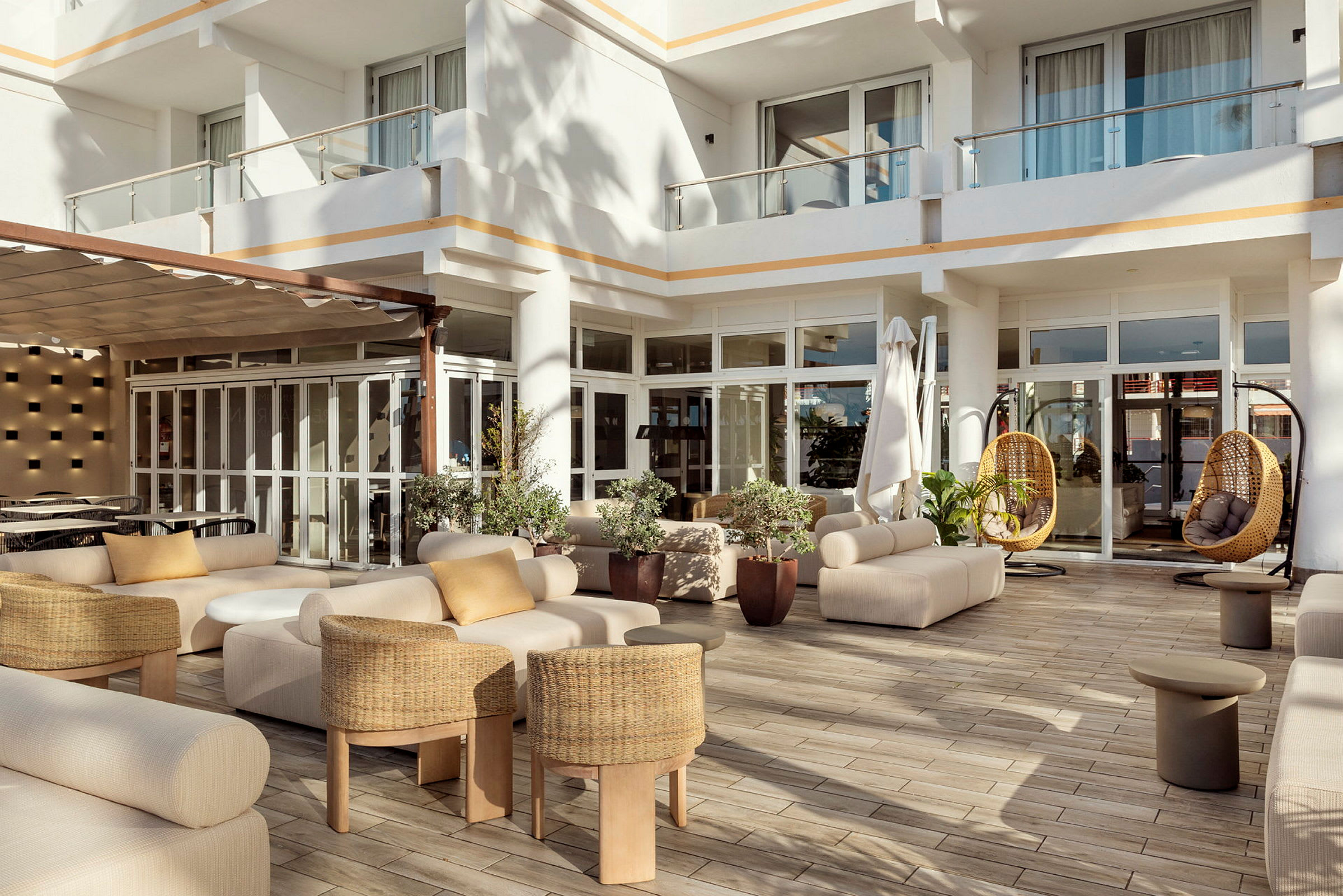 En moderne terrasse med sofaer, små bord og hengestoler i elegant design. (AI-generert tekst)