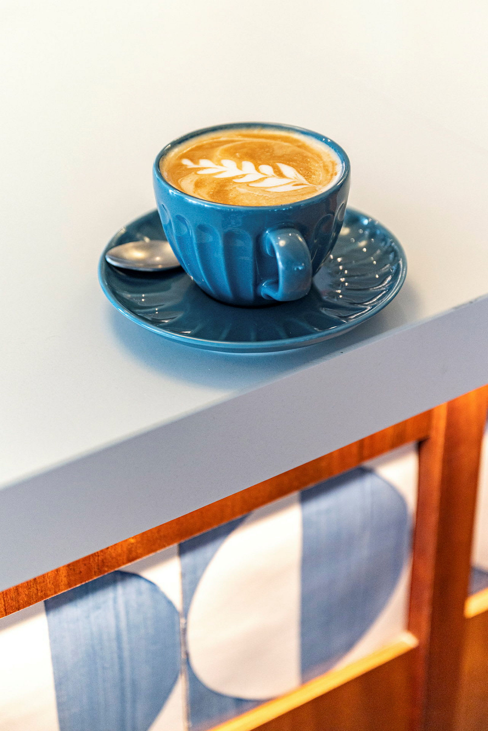 En kopp kaffe med lattekunst på et hvitt bord. (AI-generert tekst)
