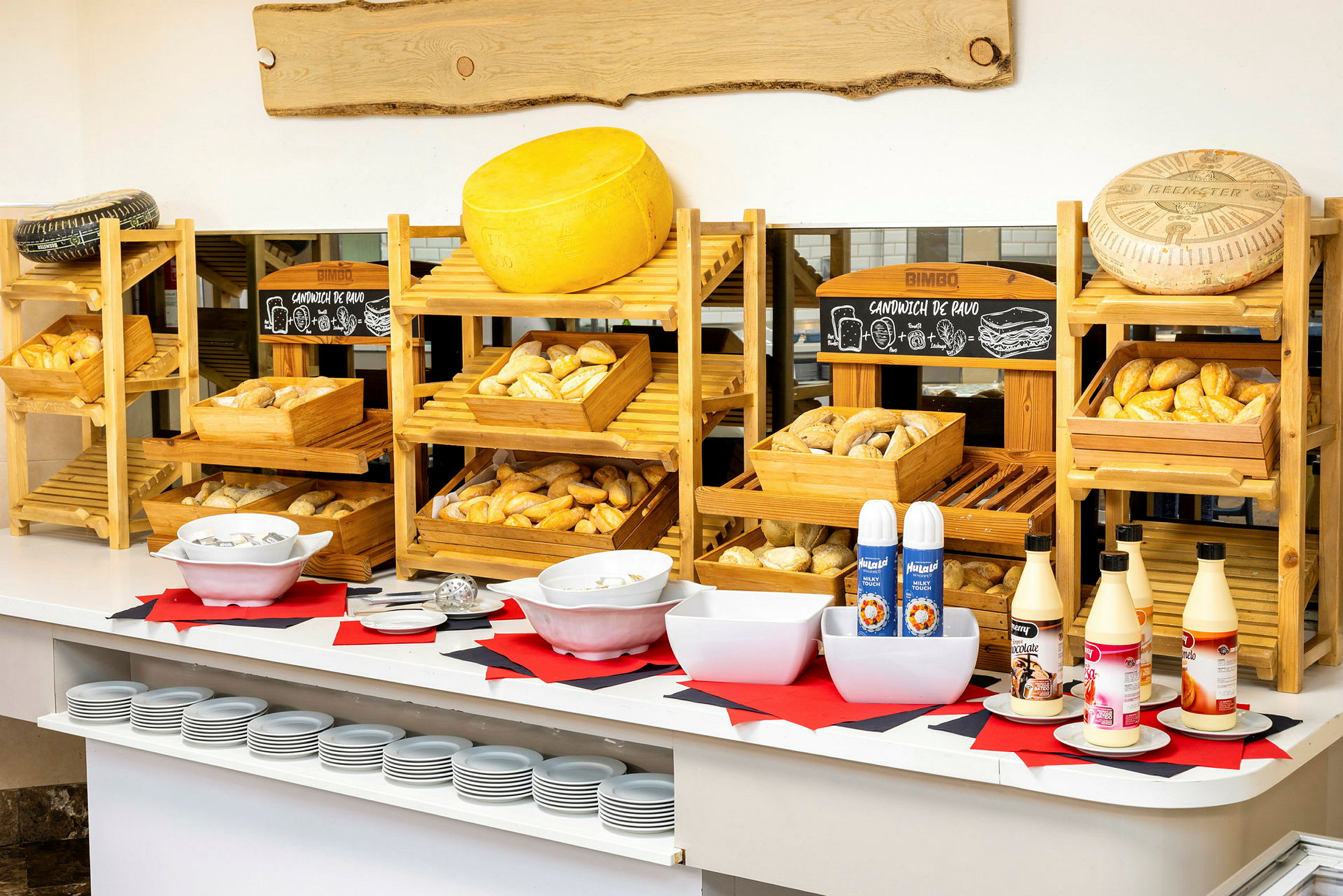 En buffet med brød, ost og sauser på bordet. (AI-generert tekst)