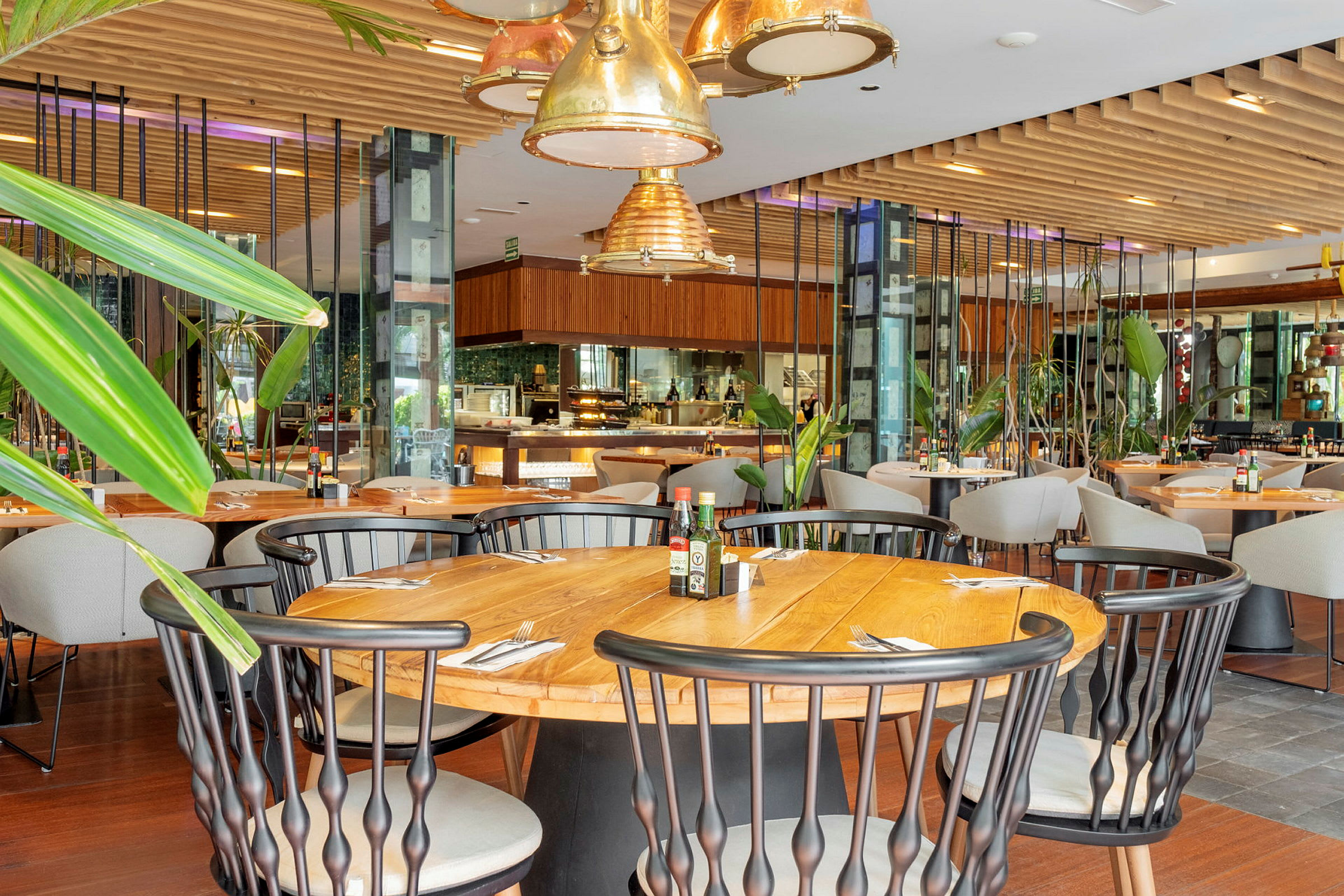 Interiør av en restaurant med trebord, stoler og grønne dekorasjoner. (AI-generert tekst)