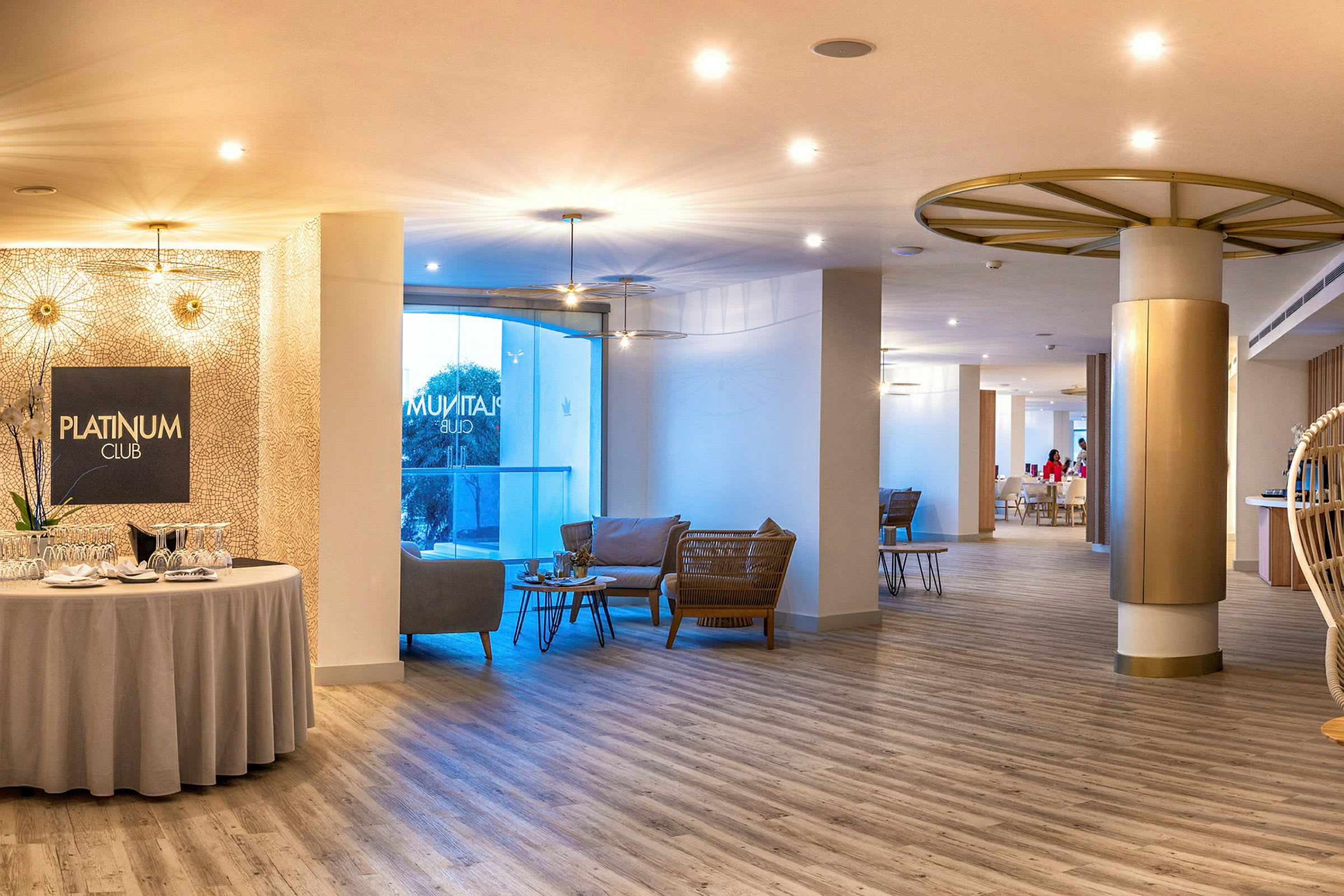 En godt opplyst lounge med sitteplasser og et skilt med teksten Platinum Club. (AI-generert tekst)