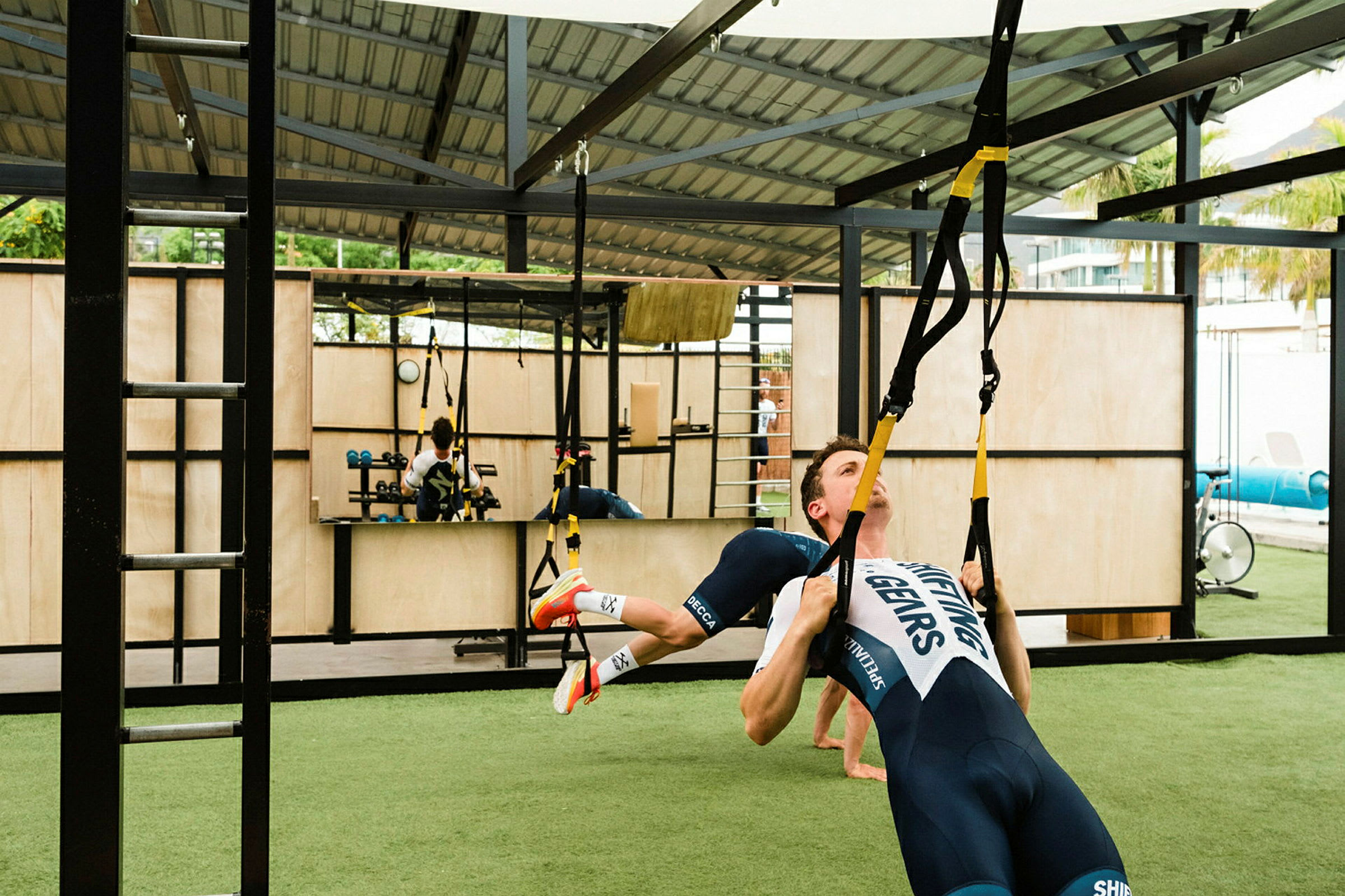 Person utfører trening med TRX-bånd på et utendørs treningssenter. (AI-generert tekst)