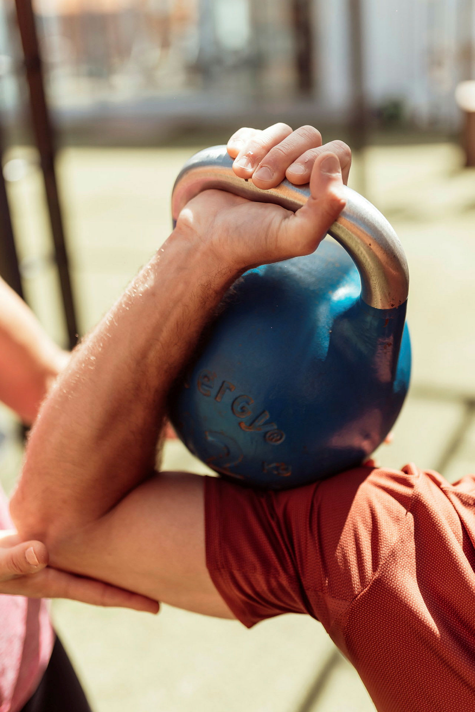 En arm holder en blå kettlebell under trening. (AI-generert tekst)