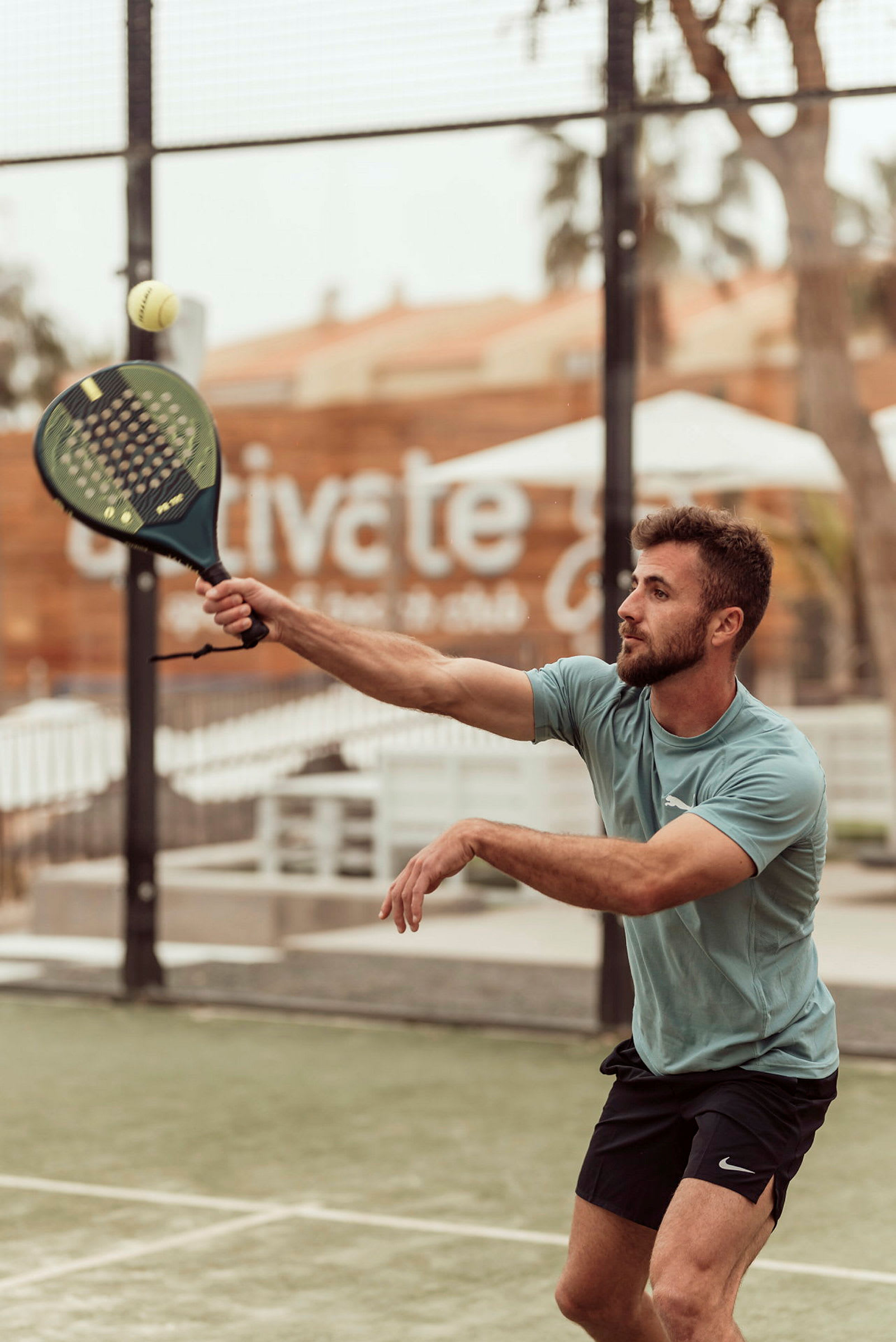 Person spiller padel og strekker seg etter ballen. (AI-generert tekst)