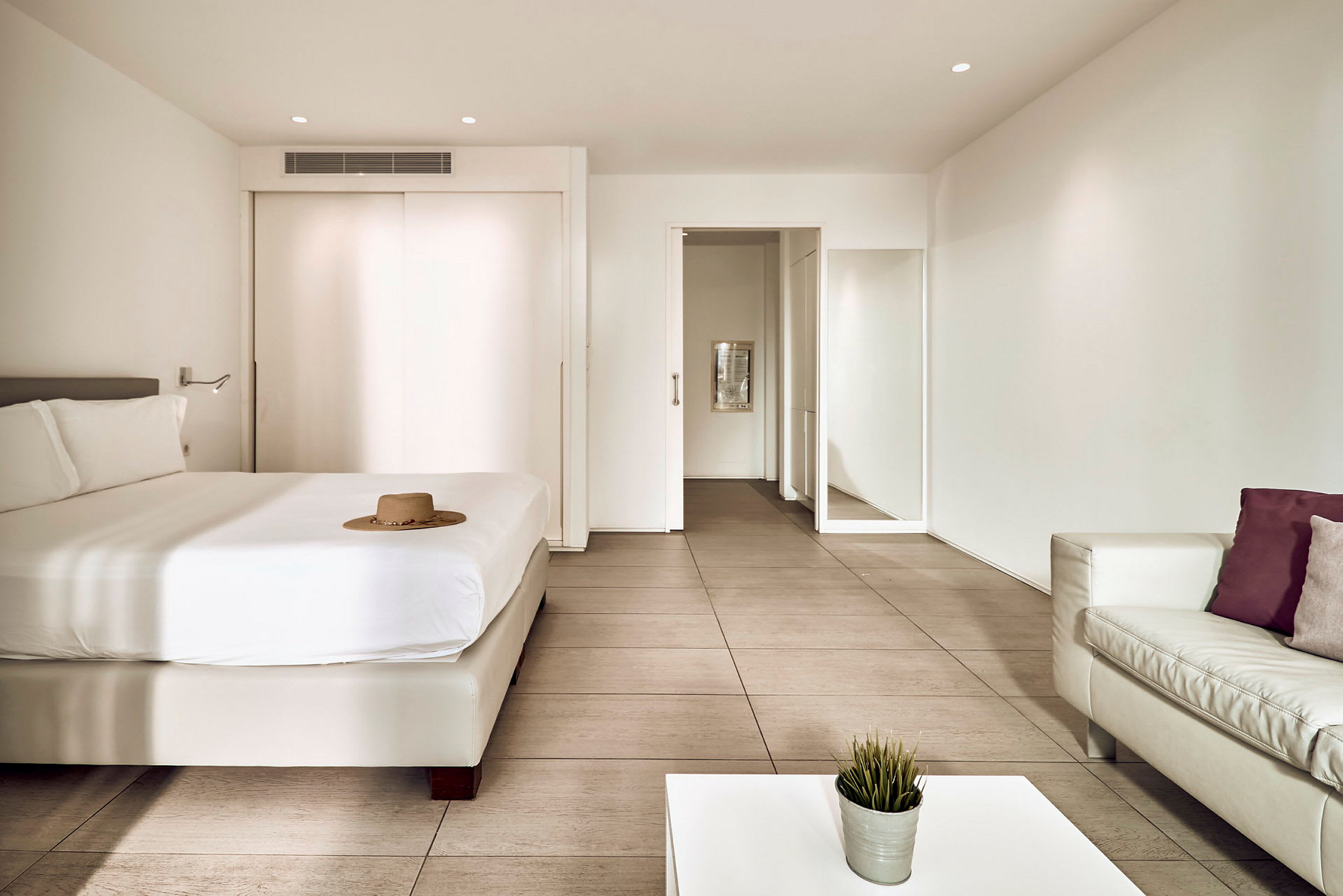 Et moderne hotellrom med en seng, sofa og bord. (AI-generert tekst)