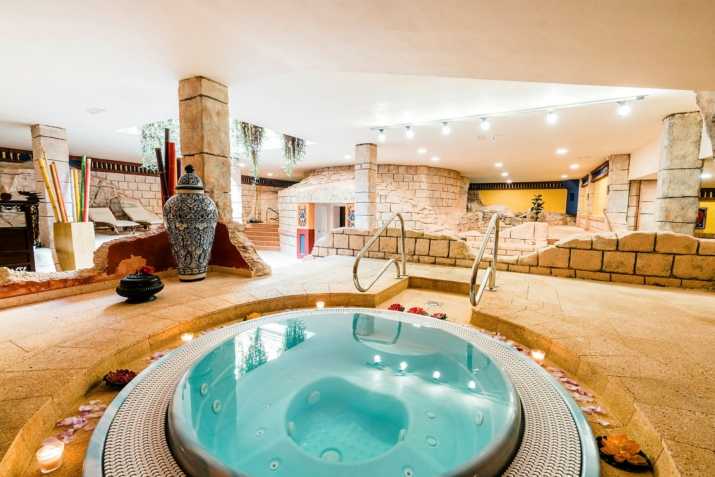 Bilde av et boblebad i et innendørs spa med steininteriør og dekorative gjenstander. (AI-generert tekst)
